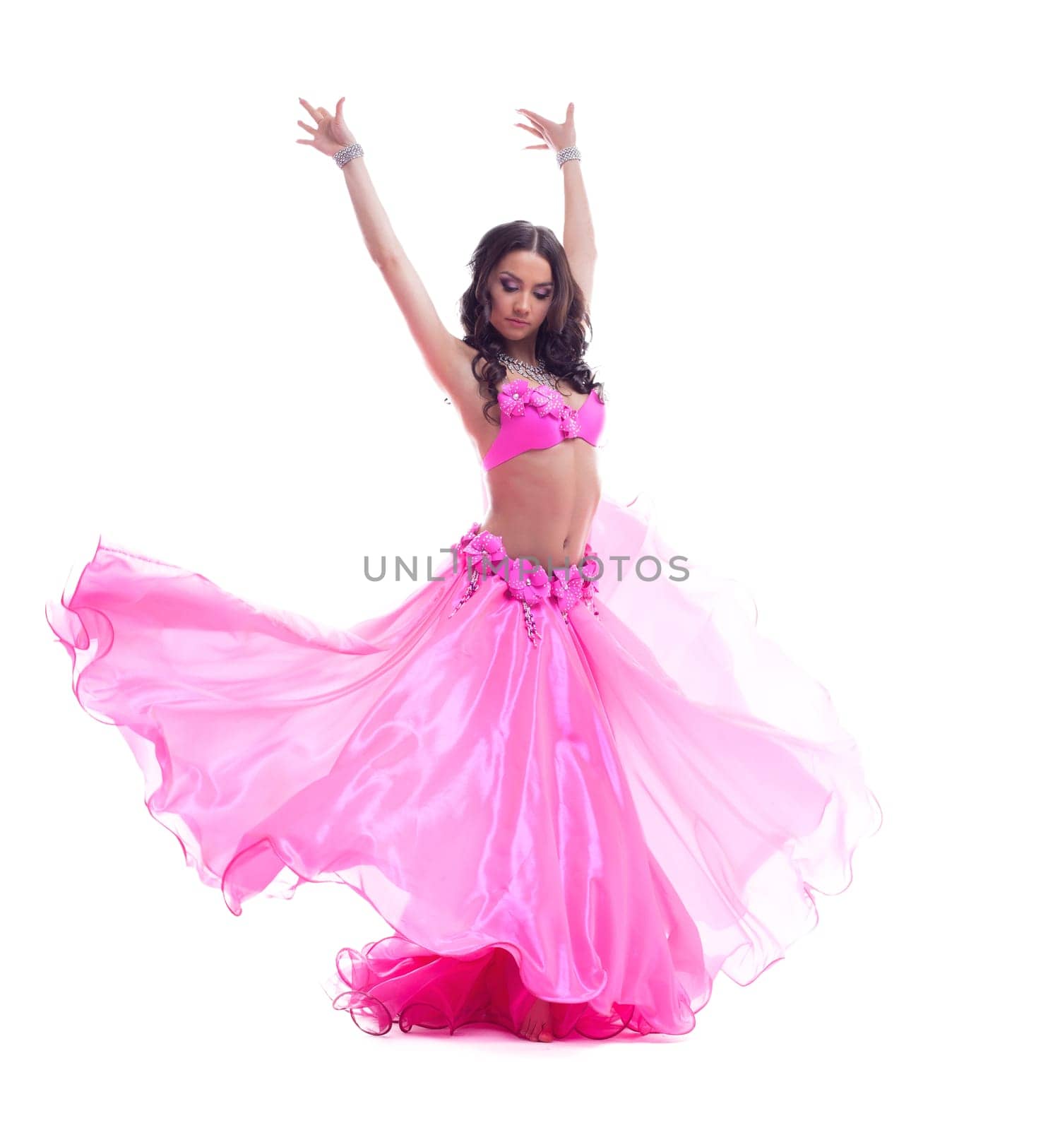 Full length portrait of beautiful dancer in pink costume performing oriental dance. Isolated on white