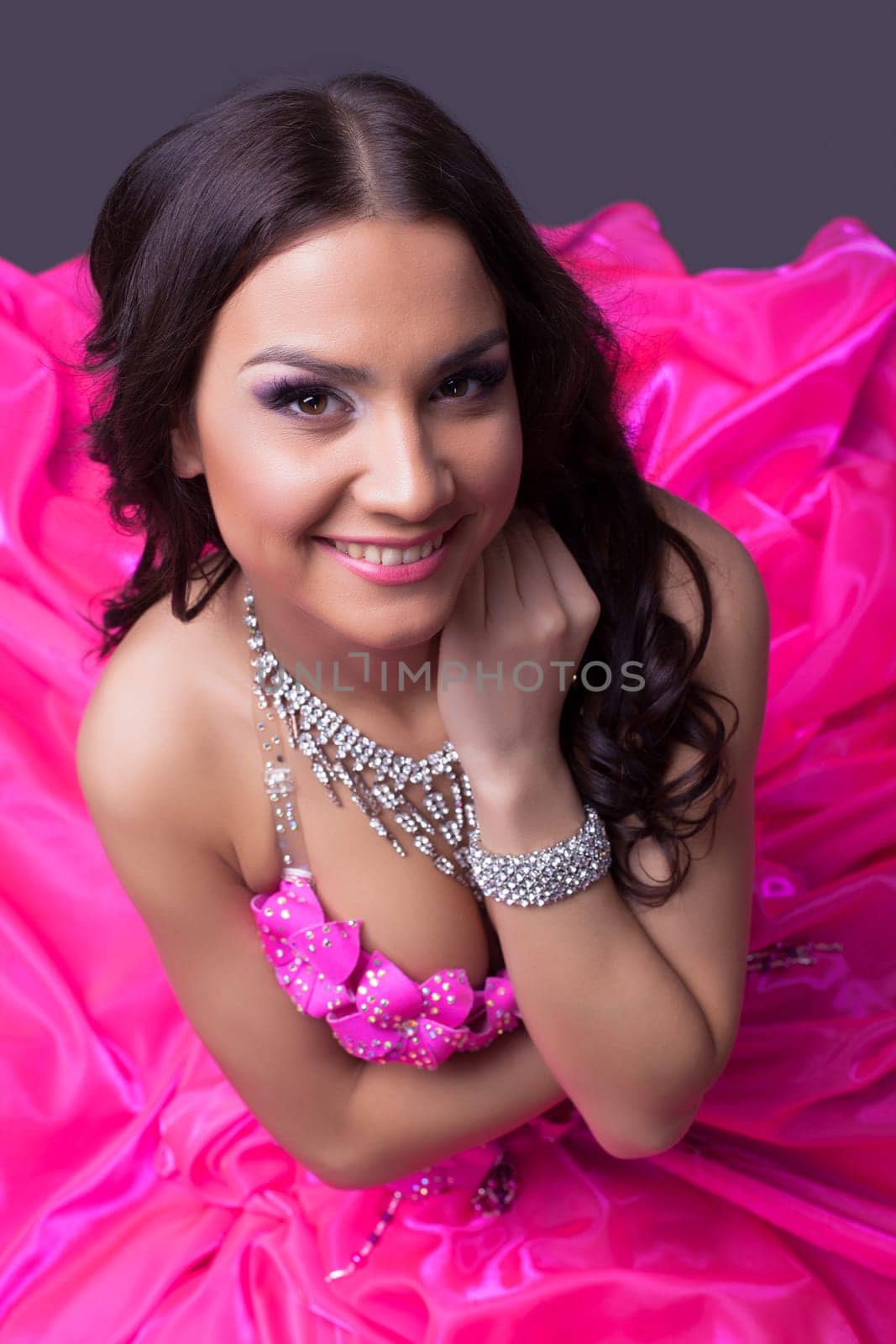 Studio portrait of beautiful young dancer in pink costume look at camera
