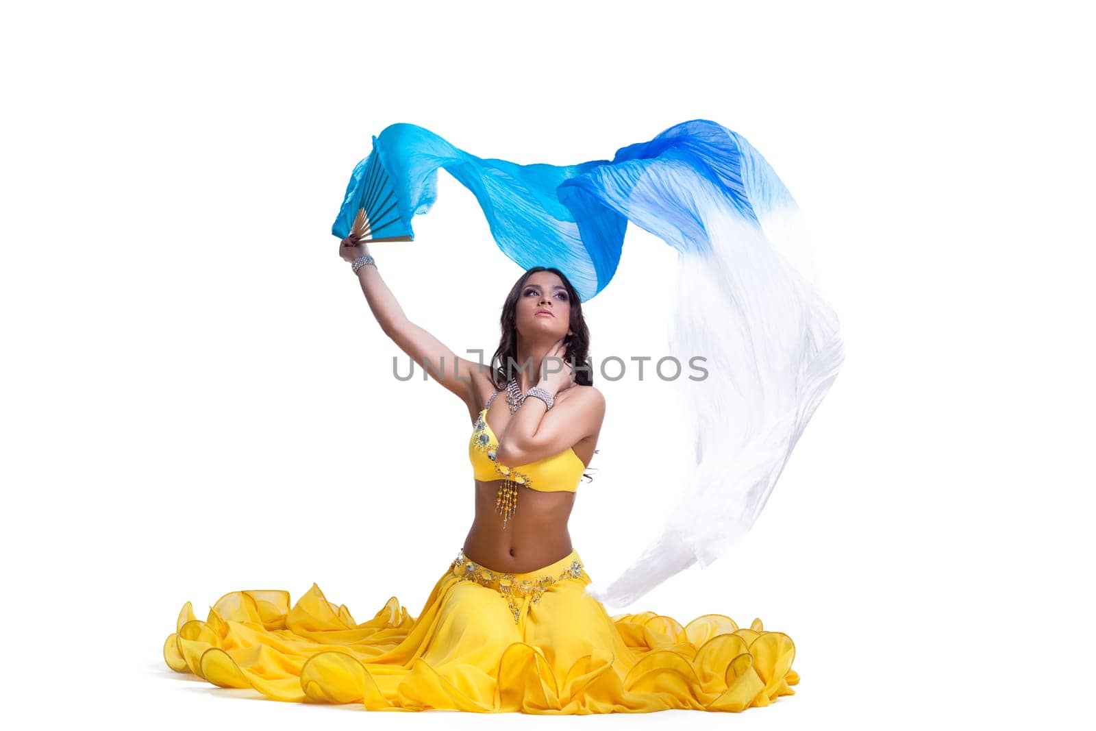 Brunette young woman performing arabic dance. Isolated on white