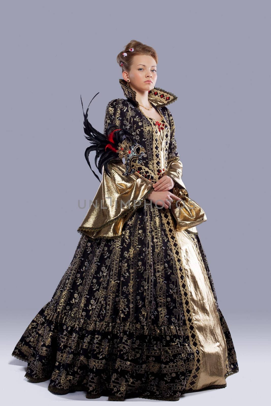 Full length portrait of young model in carnival costume middle age with mask