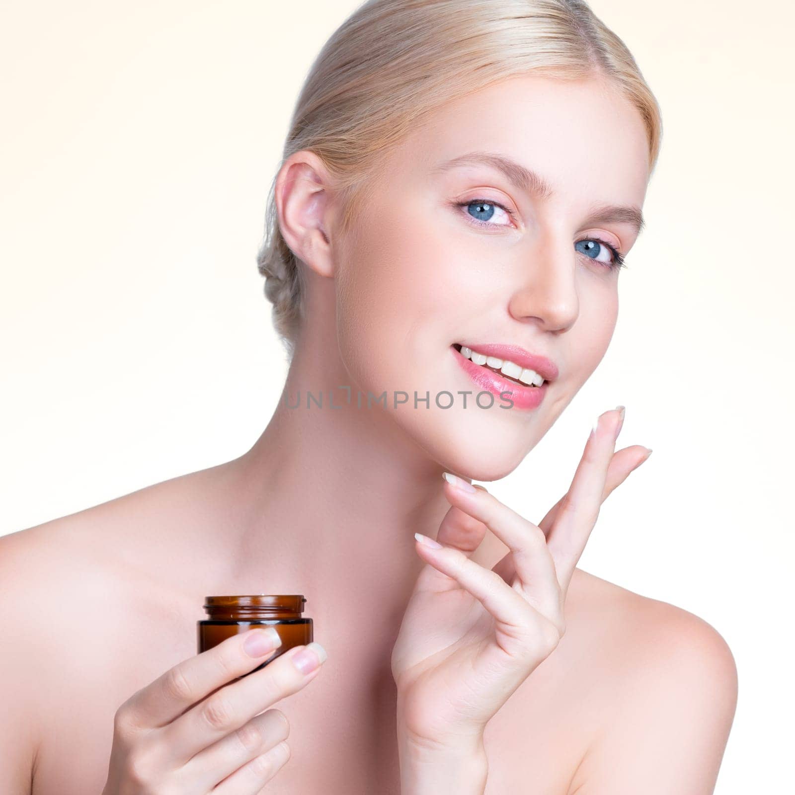 Closeup personable woman applying moisturizer cream on her face for perfect ski by biancoblue