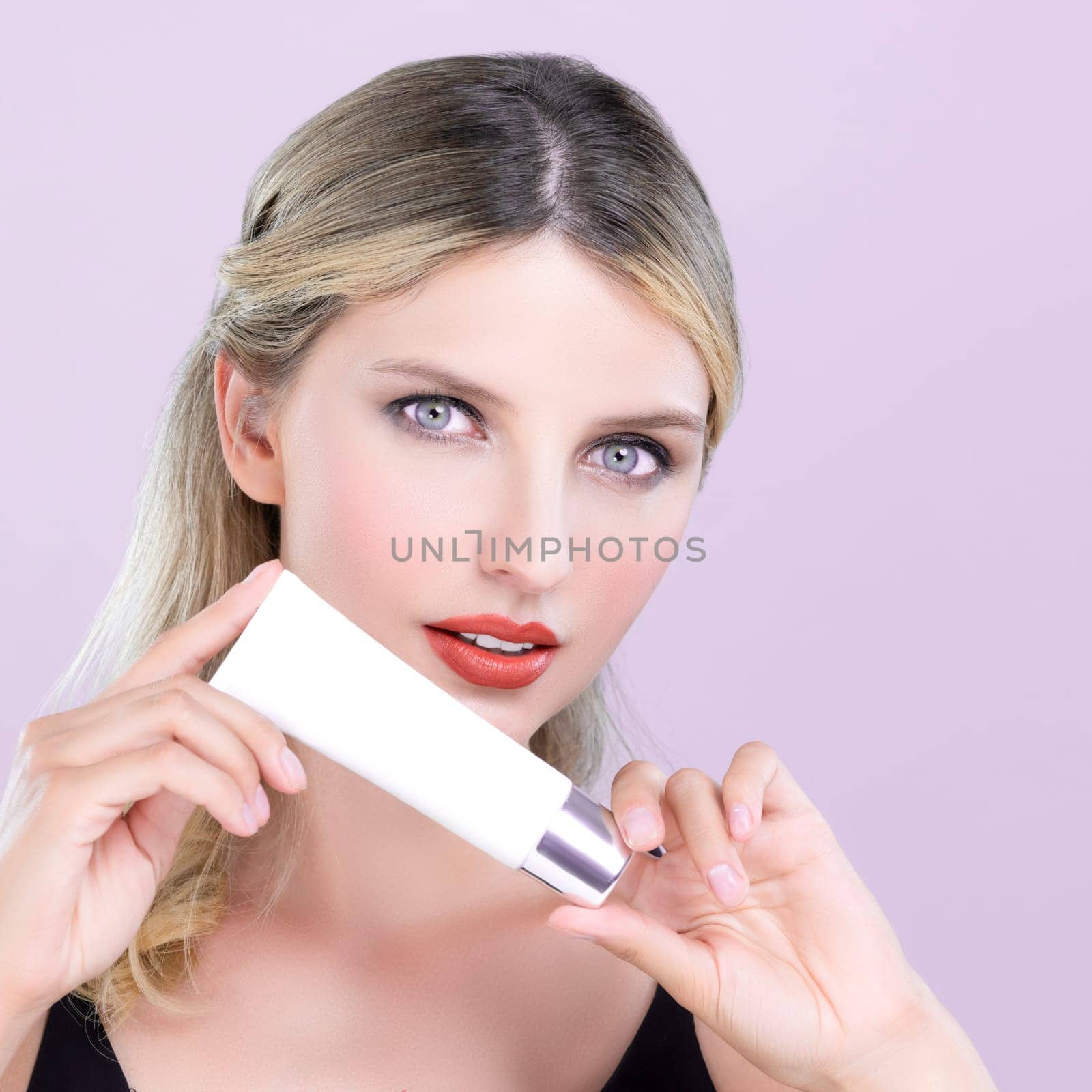 Alluring beautiful perfect cosmetic skin woman portrait hold mockup tube cream or moisturizer for skincare treatment, anti-aging product in pink isolated background. Natural healthy skin model concept