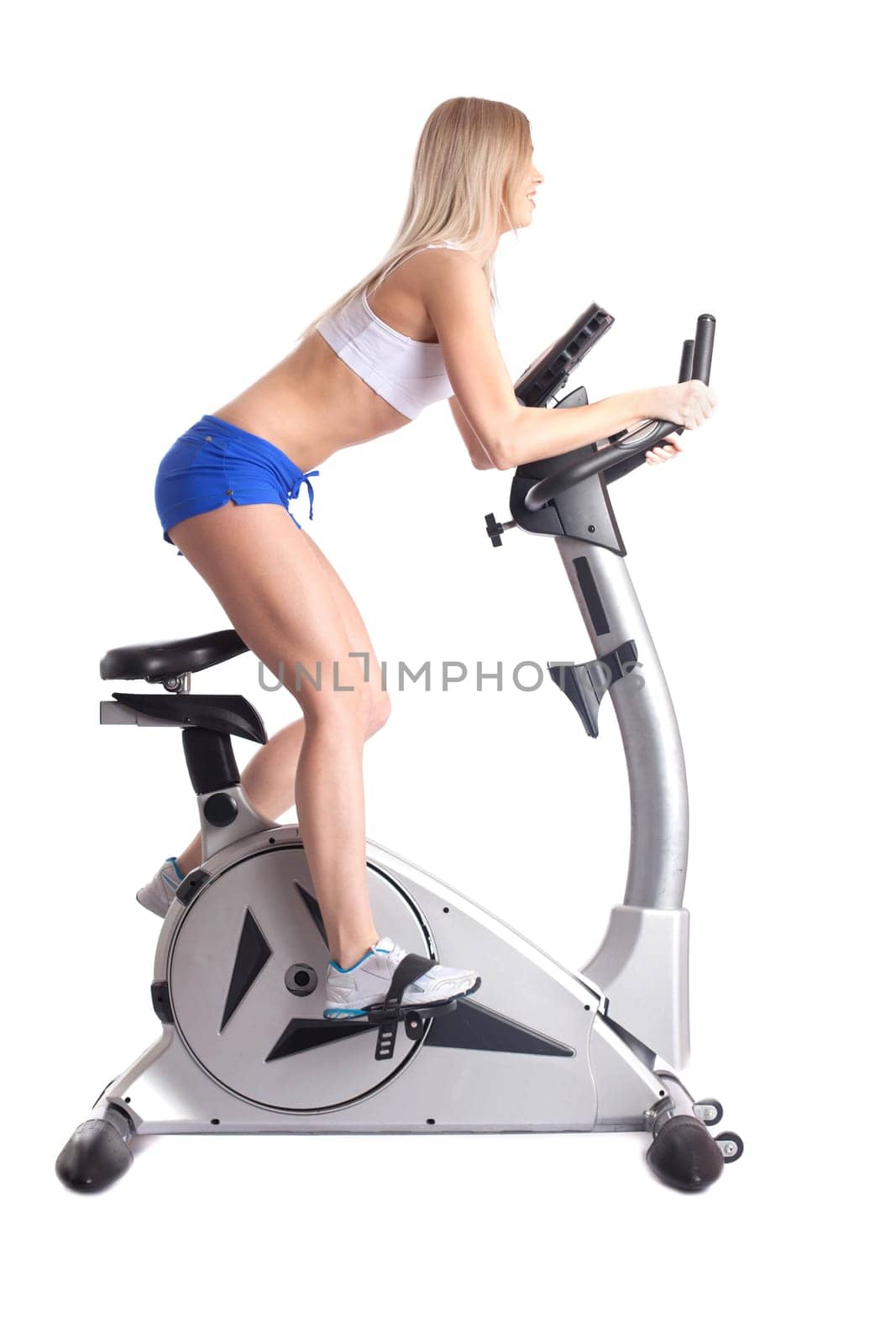 Athletic blonde training on bike exerciser, isolated on white