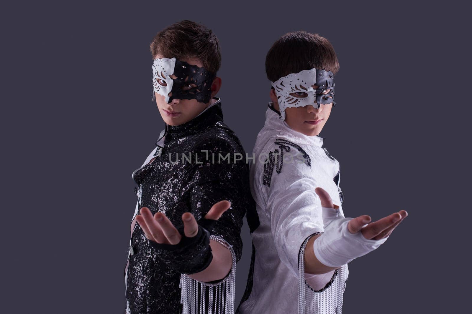 Portrait of attractive young guys in masks, on gray background