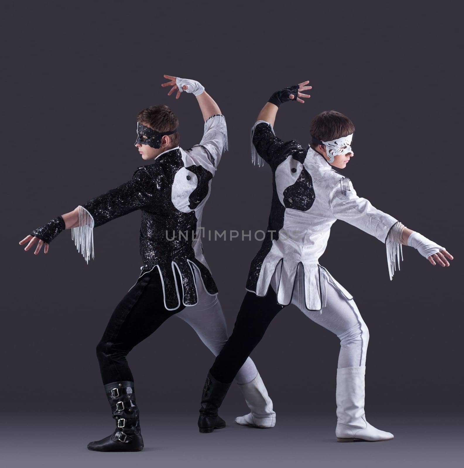 two men in carnival costumes posing in studio, on gray background