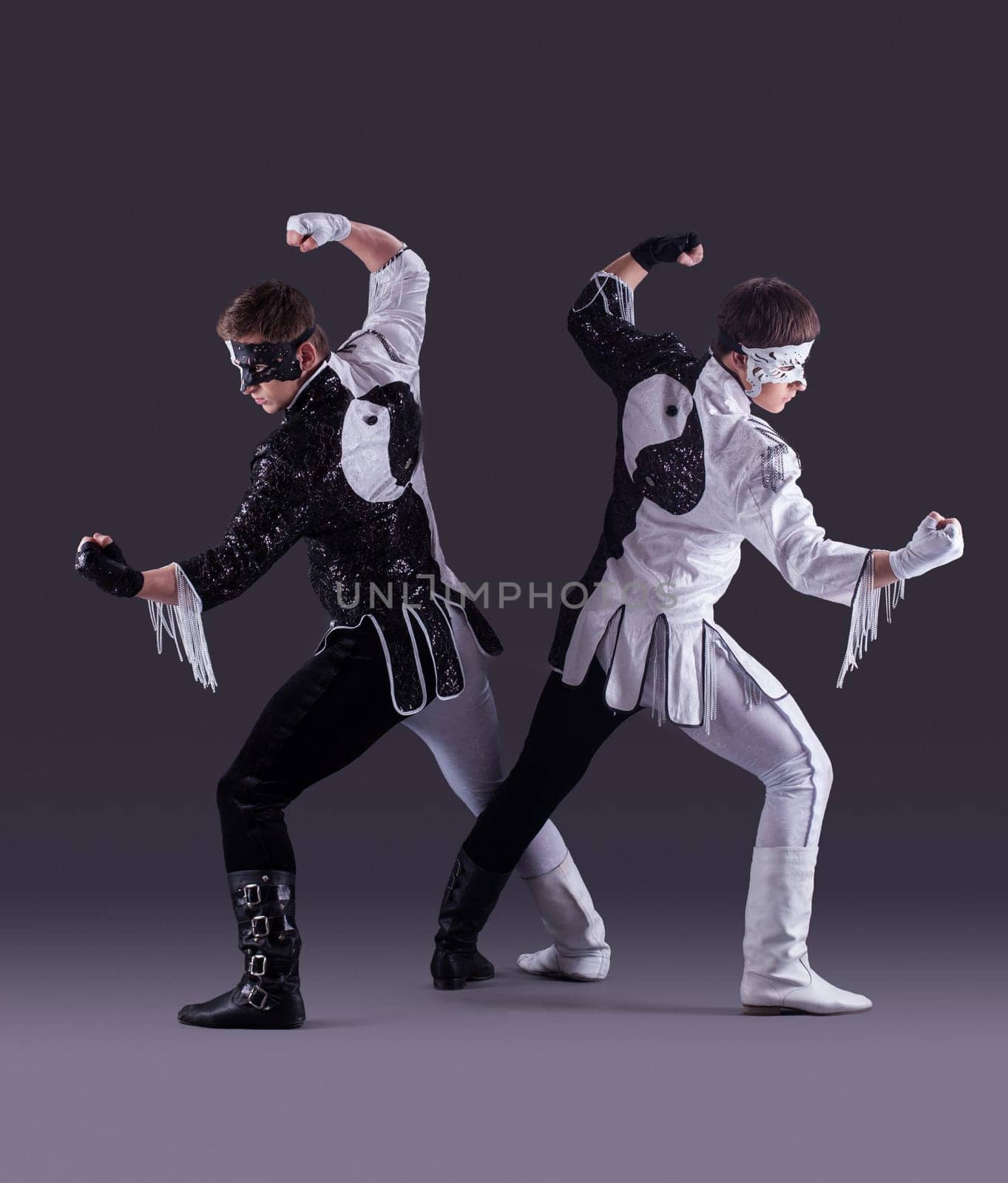 Men posing in carnival costumes on gray background