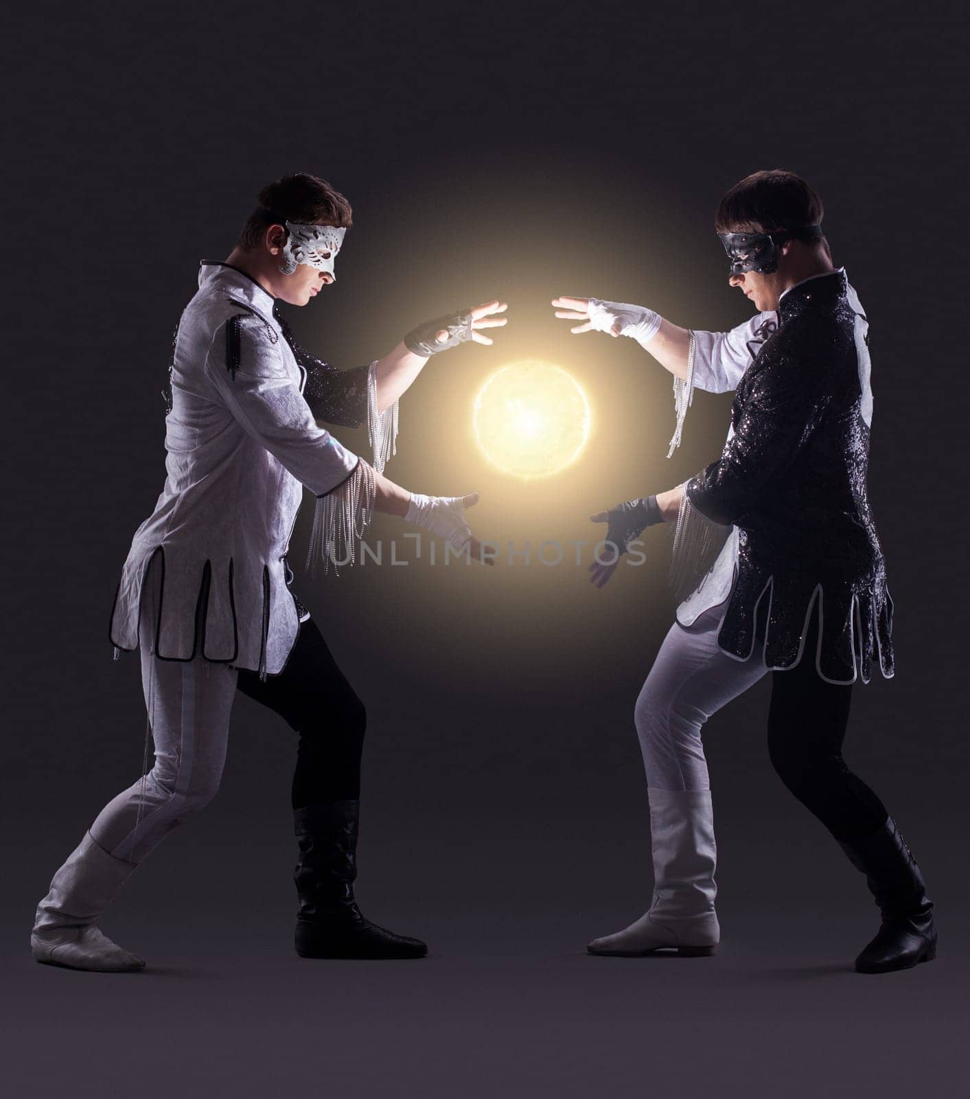 Two magicians creating fireball, on gray background