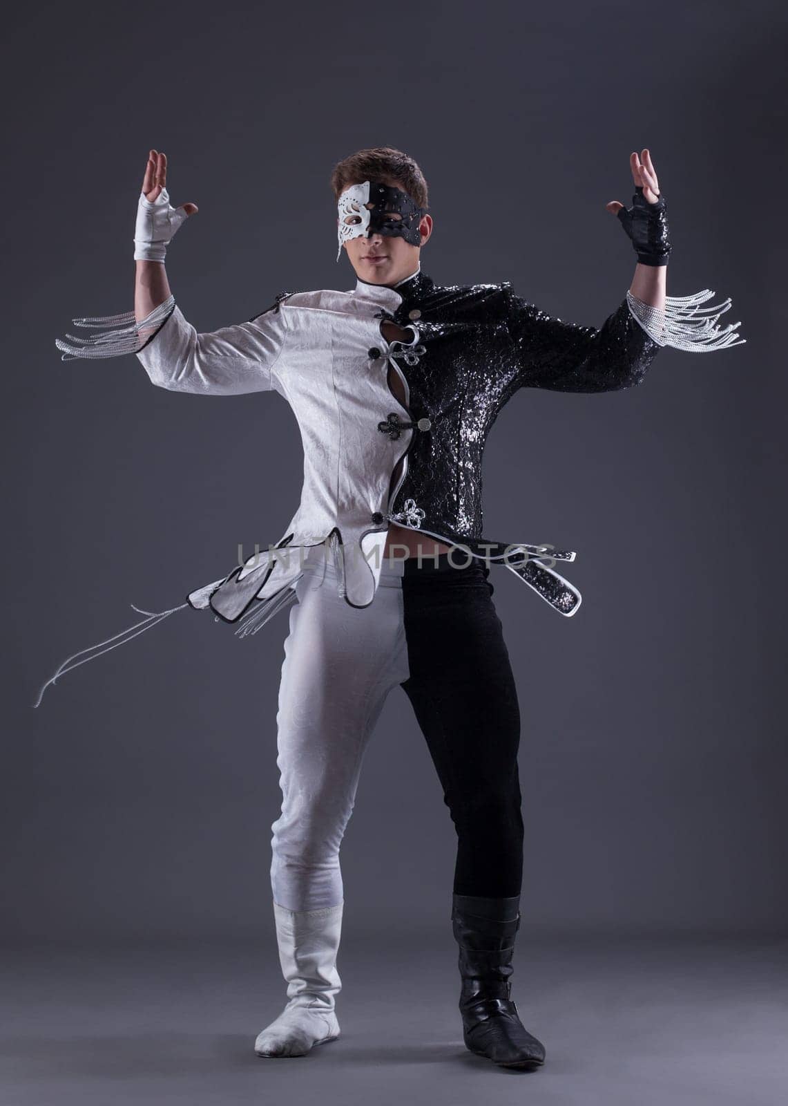 young man in black and white fancy dress, on gray background