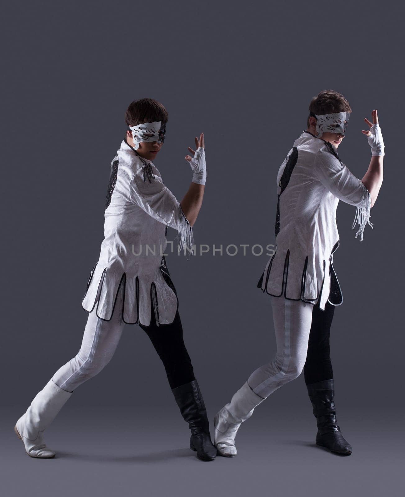Attractive men in masquerade costumes, on gray background