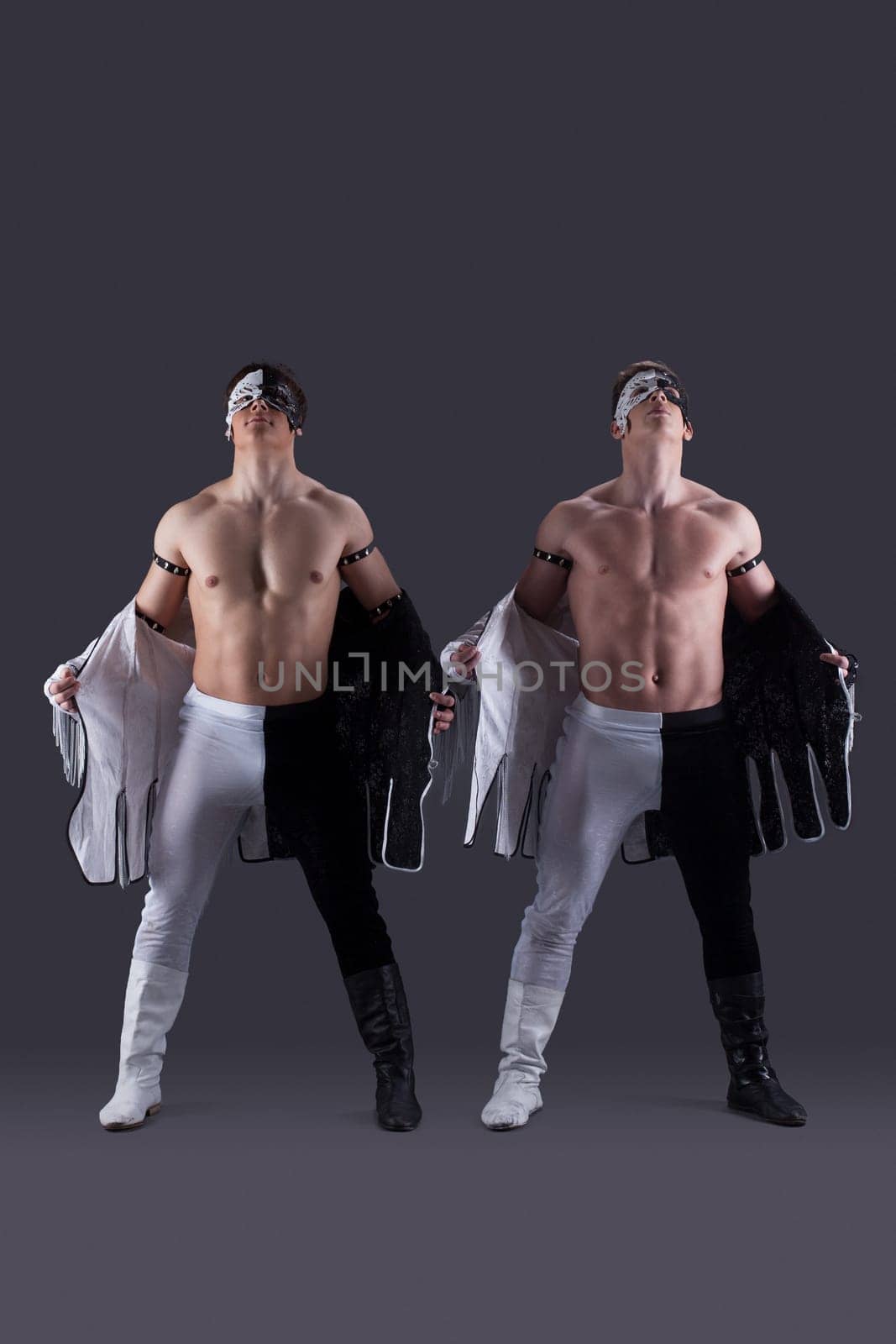 Handsome muscular guys take off their clothes, on gray background