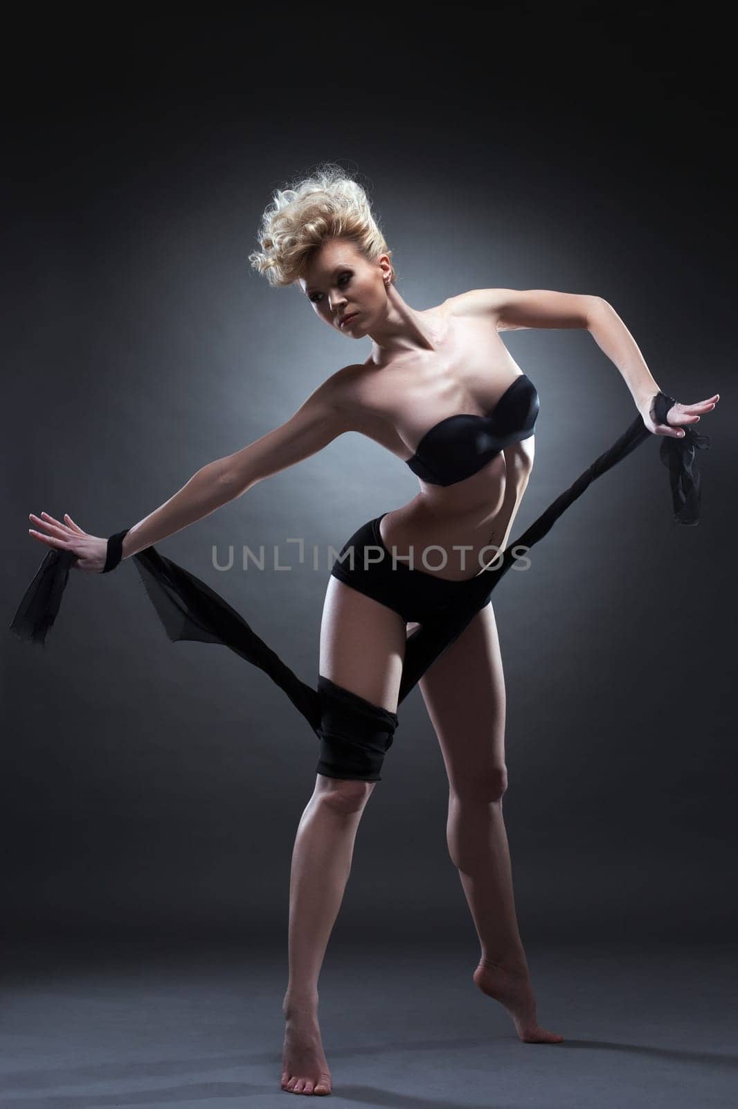 Full length portrait of slim blonde woman in black underwear