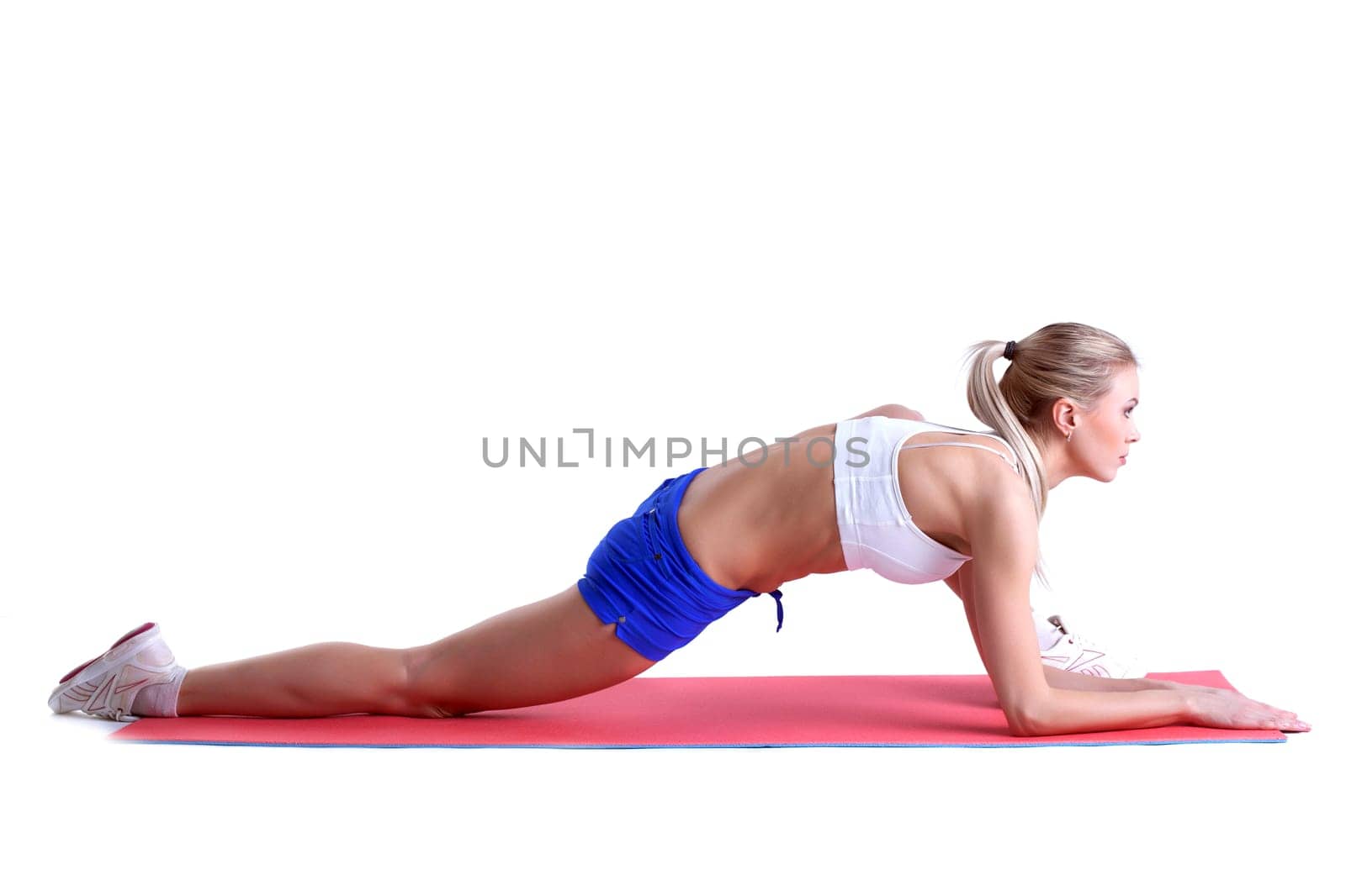 Sporty woman doing stretching exercises on mat, isolated over white background