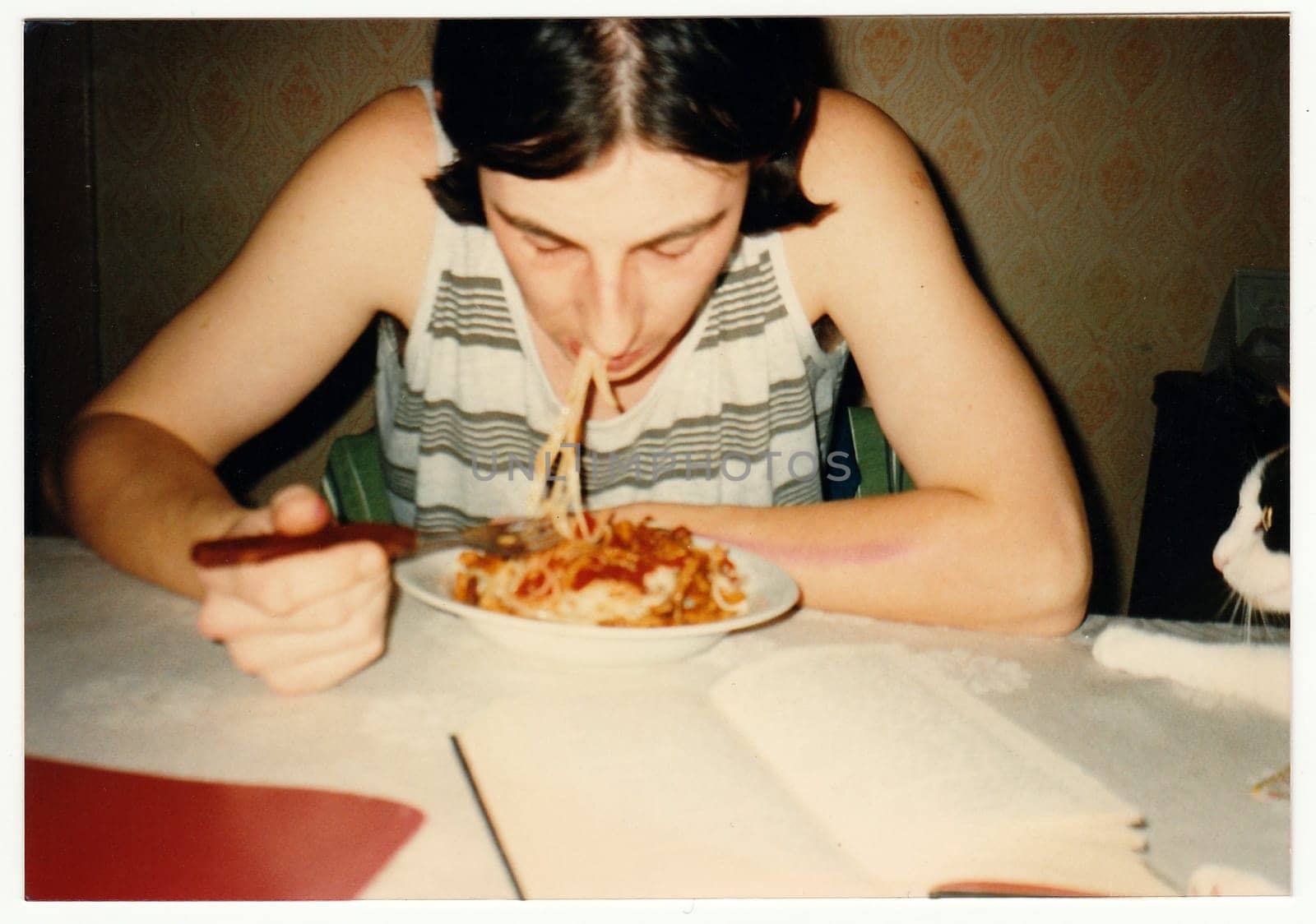 THE CZECHOSLOVAK REPUBLIC - CIRCA 1990s: Retro photo shows boy eats spaghetti at the table.
