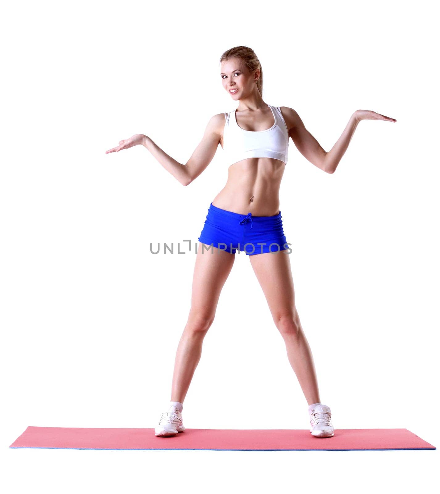 Cheerful slim woman posing on mat in studio by rivertime