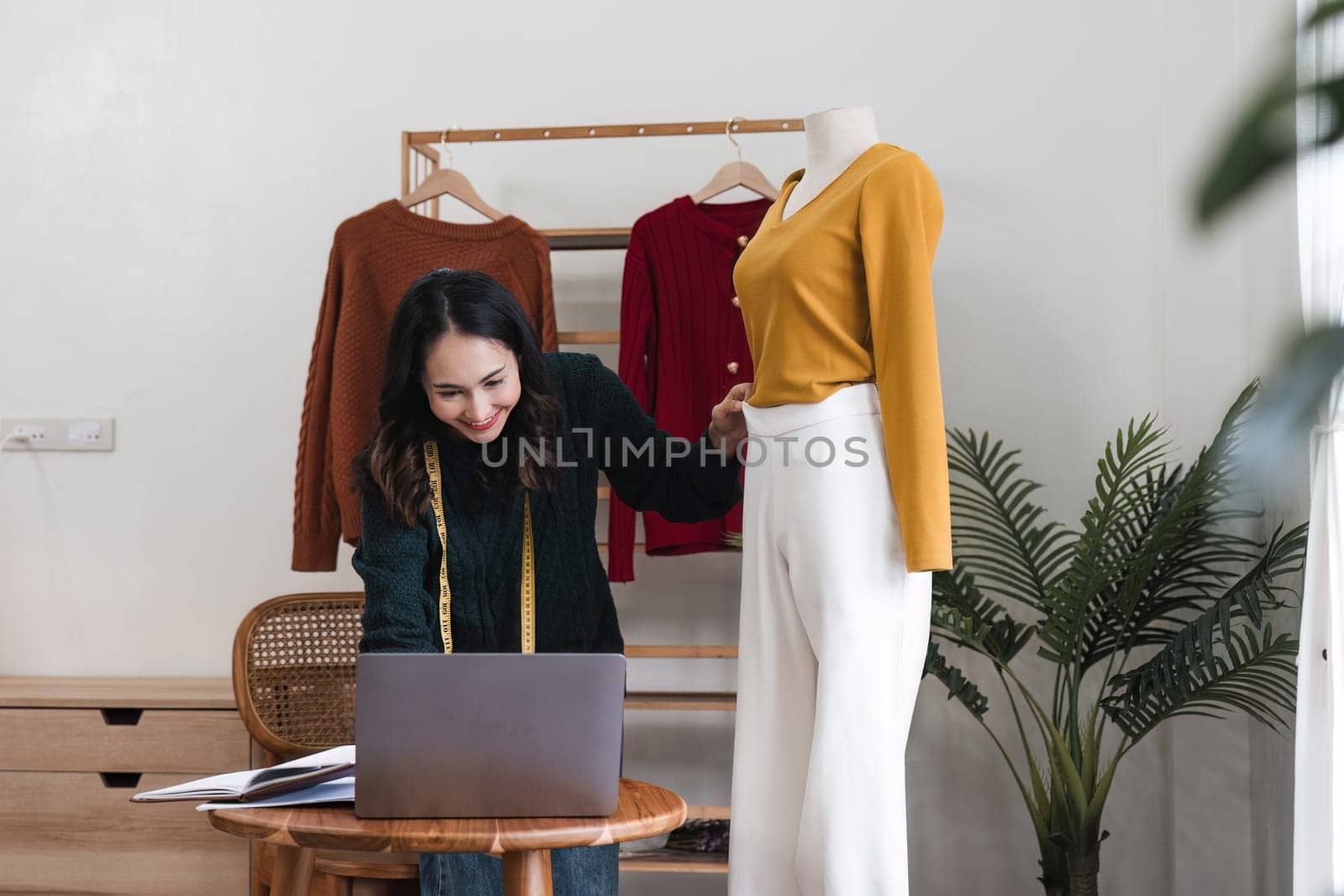 Female stylist Successful Fashion Business. Portrait of Smiling Asian Designer stylish standing and working at fashion studio. Portrait of fashion designer in office by nateemee