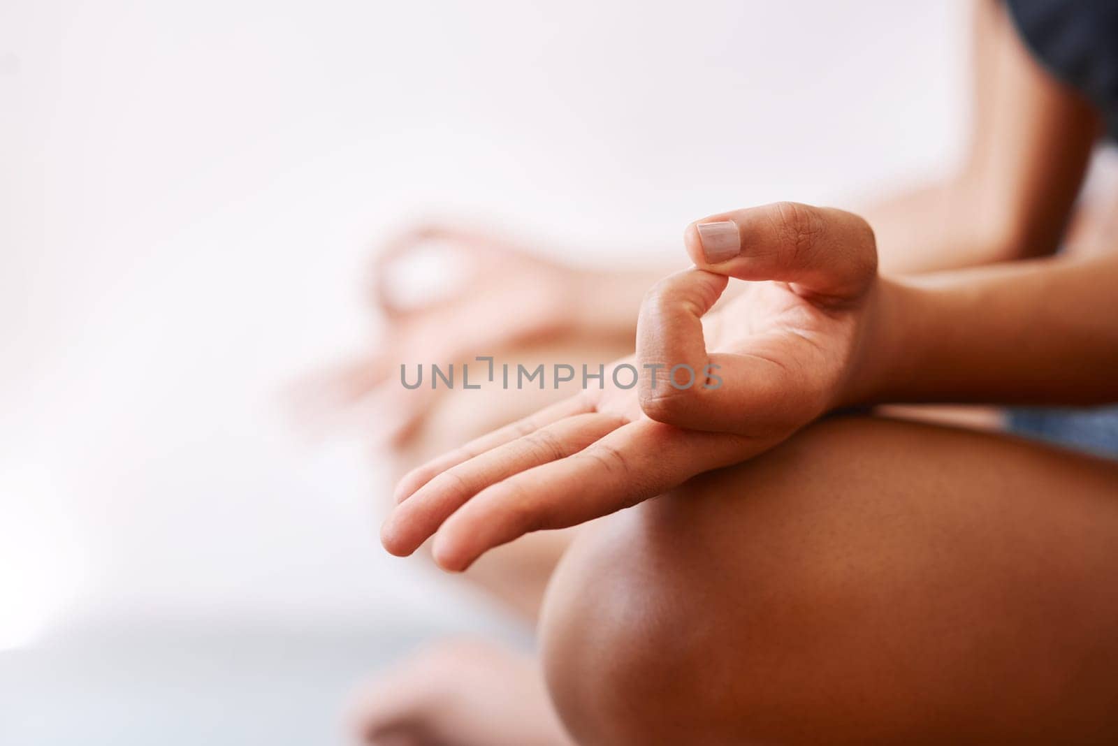 I do yoga for a better mind and body. an unrecognizable woman practising yoga against a white background. by YuriArcurs