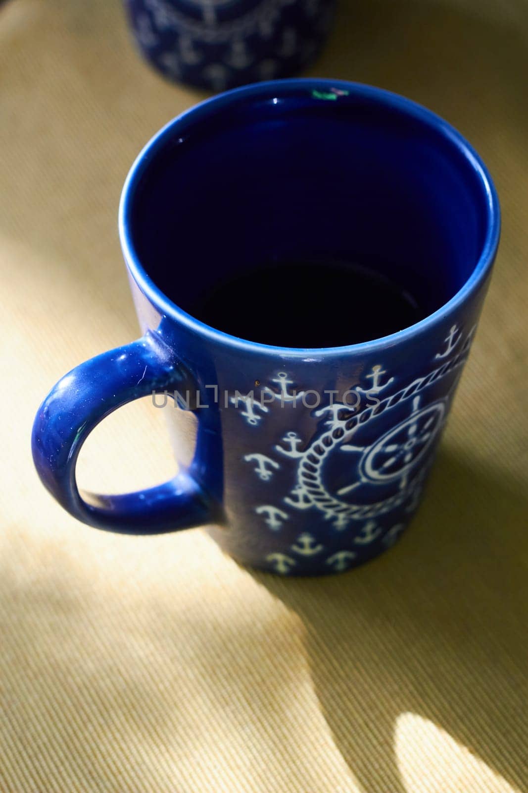 Blue ceramic cup handwheels pattern on the table. by electrovenik