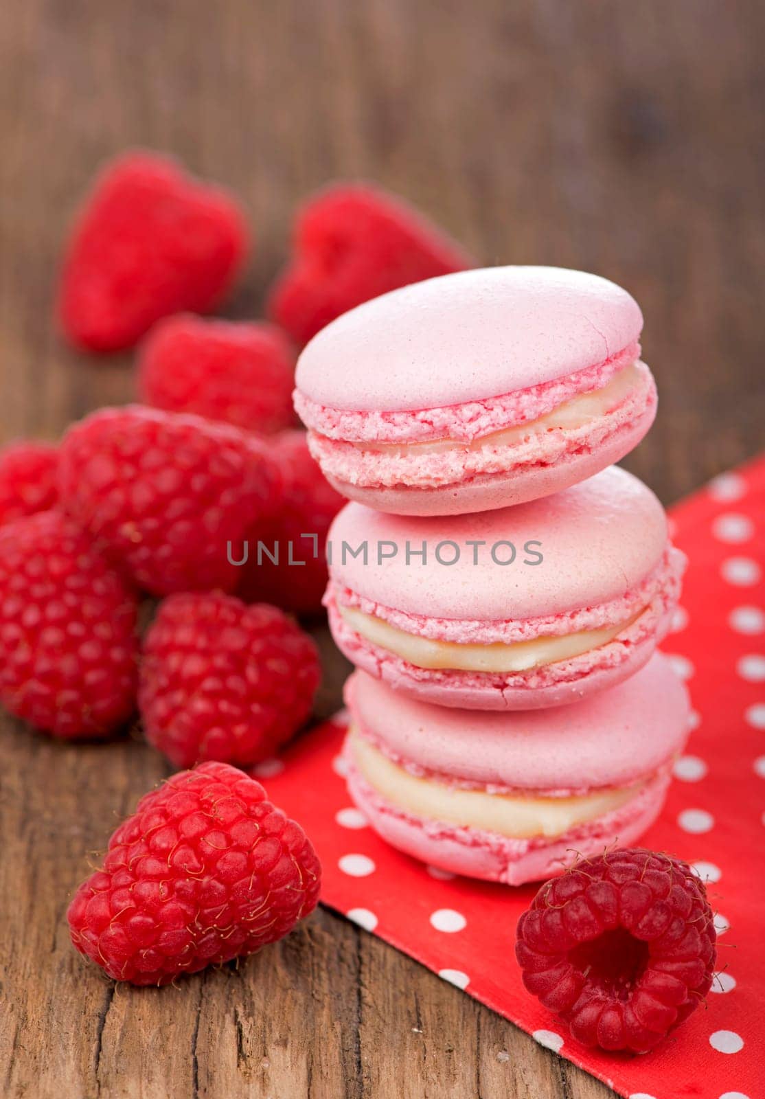 French makarons cake . Pink raspberry macaron cookies on dark wooden boards by aprilphoto