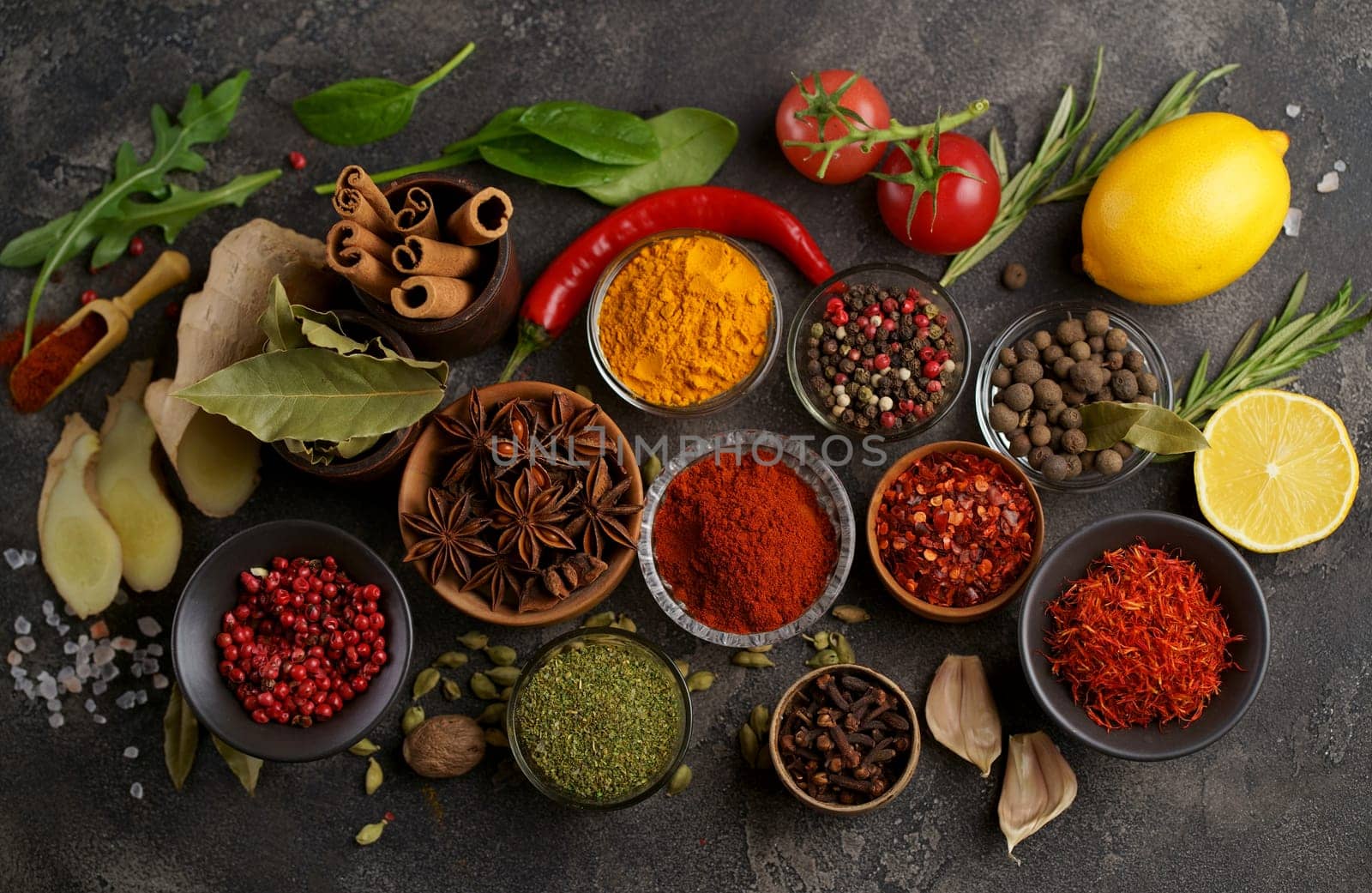 Set of spices and herbs. Indian food. Pepper, salt, paprika, basil, turmeric. On a black wooden board. View from above. Free copy space. by aprilphoto