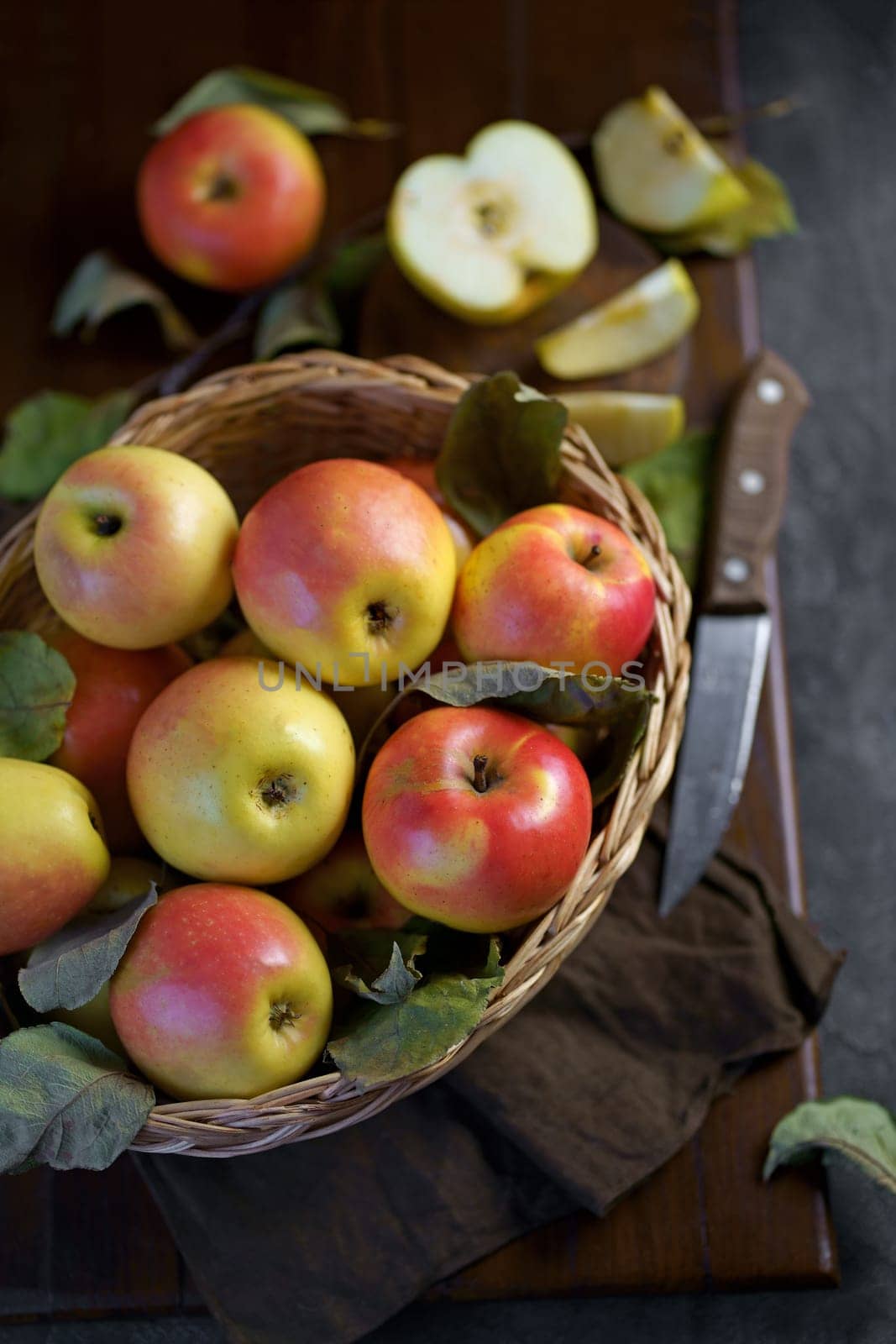Ripe apples in a basket, with leaves around it by aprilphoto