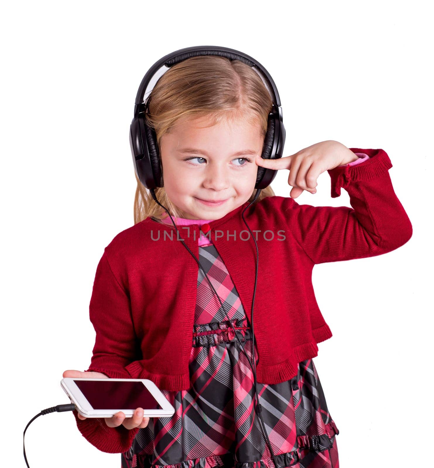 Little blonde girl smiling listening to music on smart phone mobile device with headphones