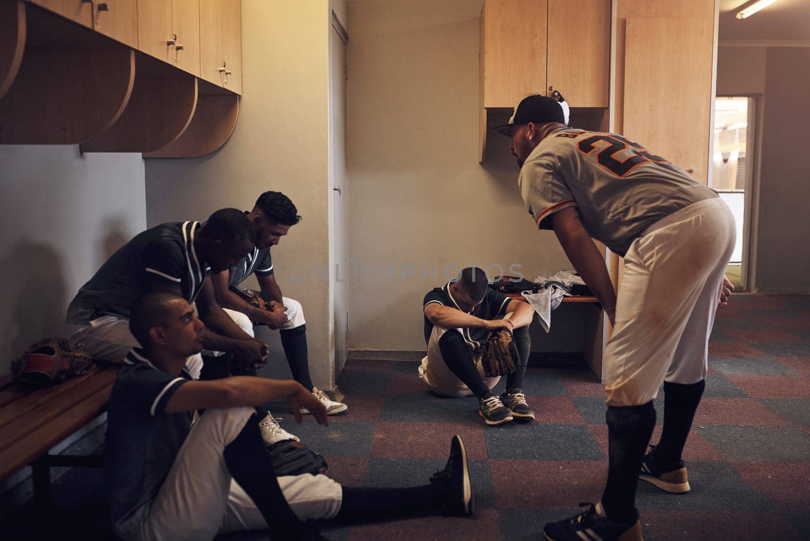 The best way to learn is by losing. a young man yelling at his fellow baseball players in a locker room