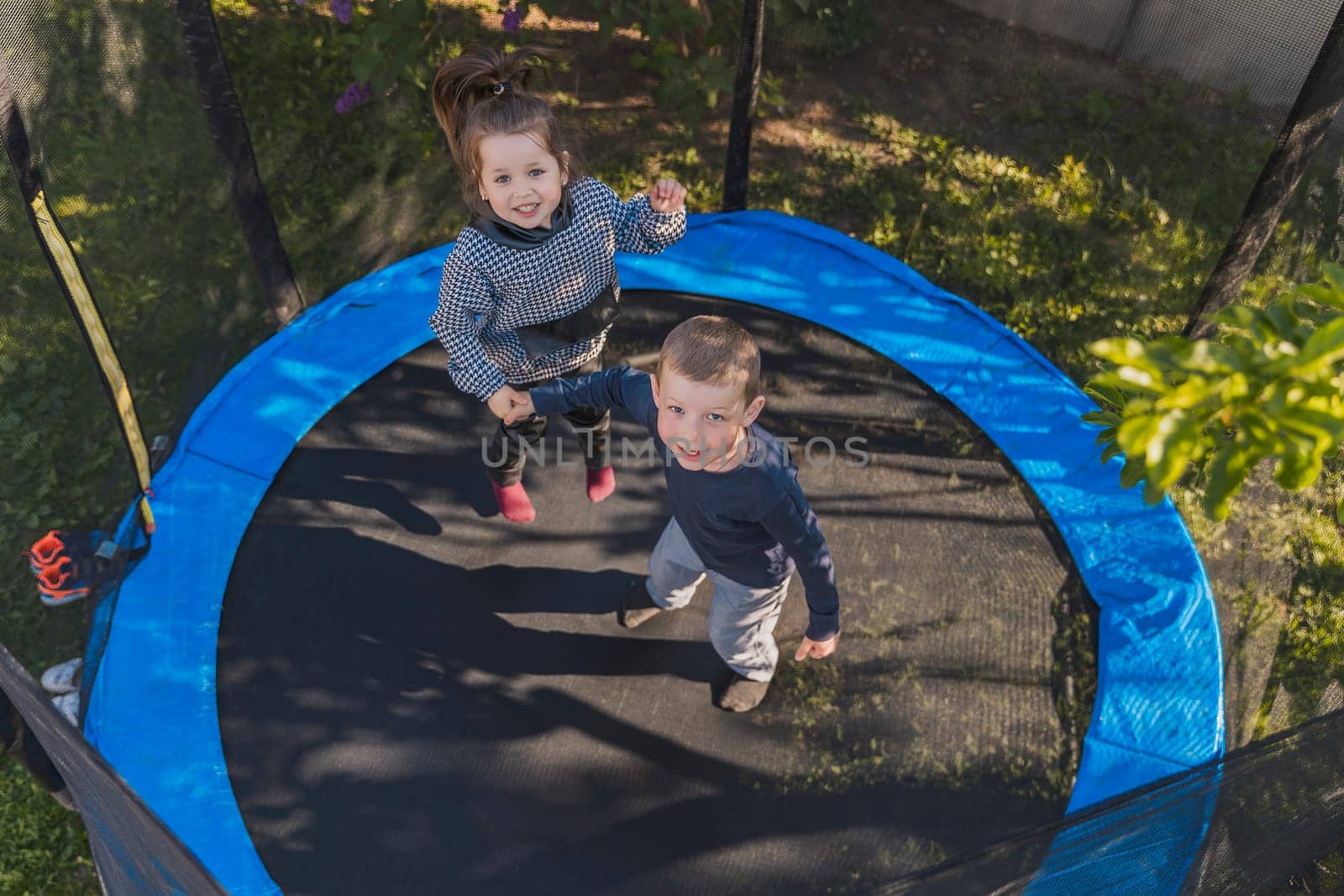 children jumping on a trampoline top view