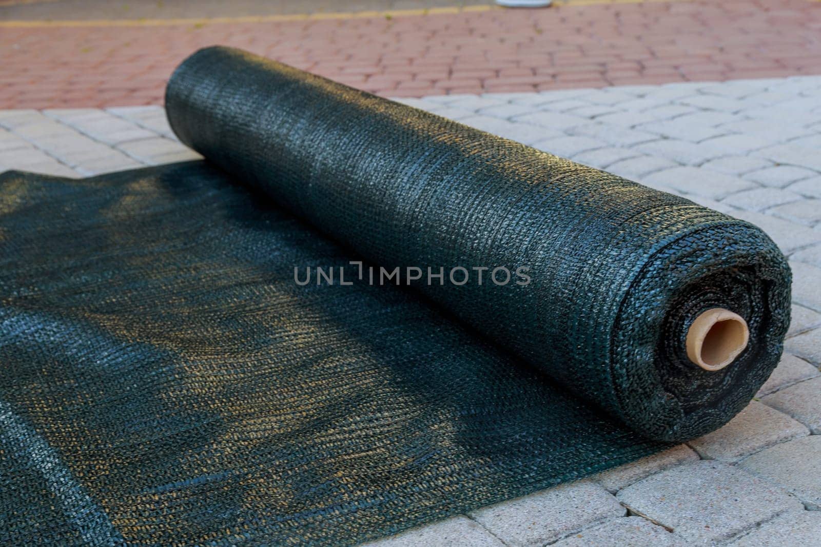 A roll of green shading netting. Artificial shading of plants or grapes.