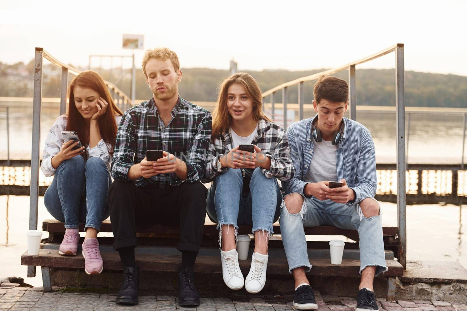 Near the lake. Group of young cheerful friends that is outdoors having fun together.