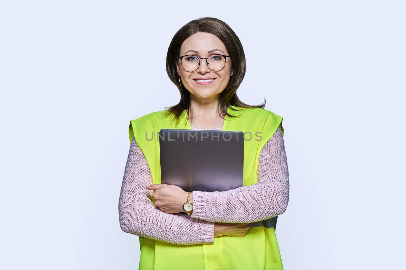 Portrait of engineer manager woman in vest holding laptop, over white studio background. Logistics, construction, industry, management, architecture, engineering, staff workers concept