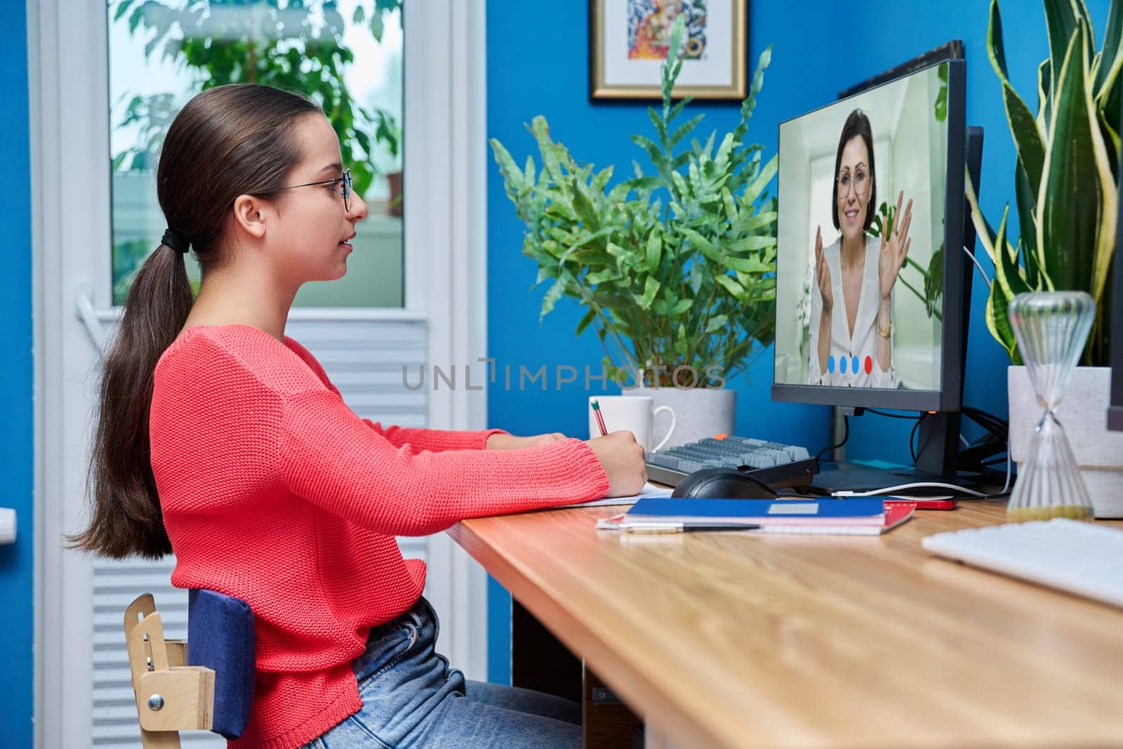 Video conference, teen girl student talking to teacher on computer screen. Teenager looking at webcam sitting at home, remote online lesson distance learning course. E-education technology high school