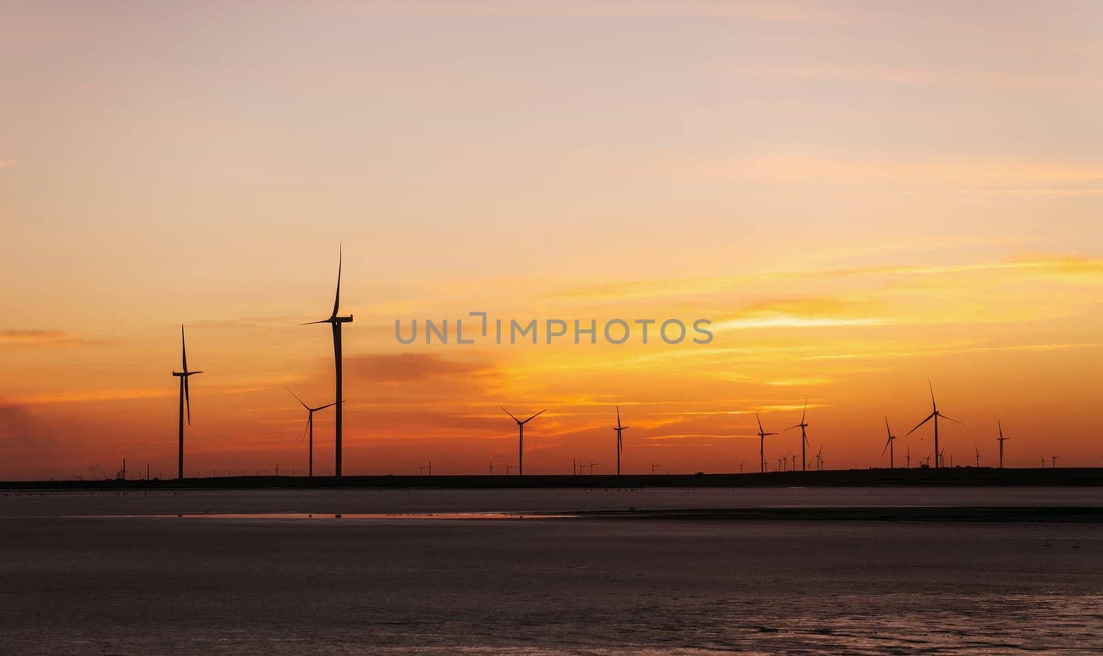 Orange sky. Many of windmills on the Jarilgach island, Ukraine. Sunset time.