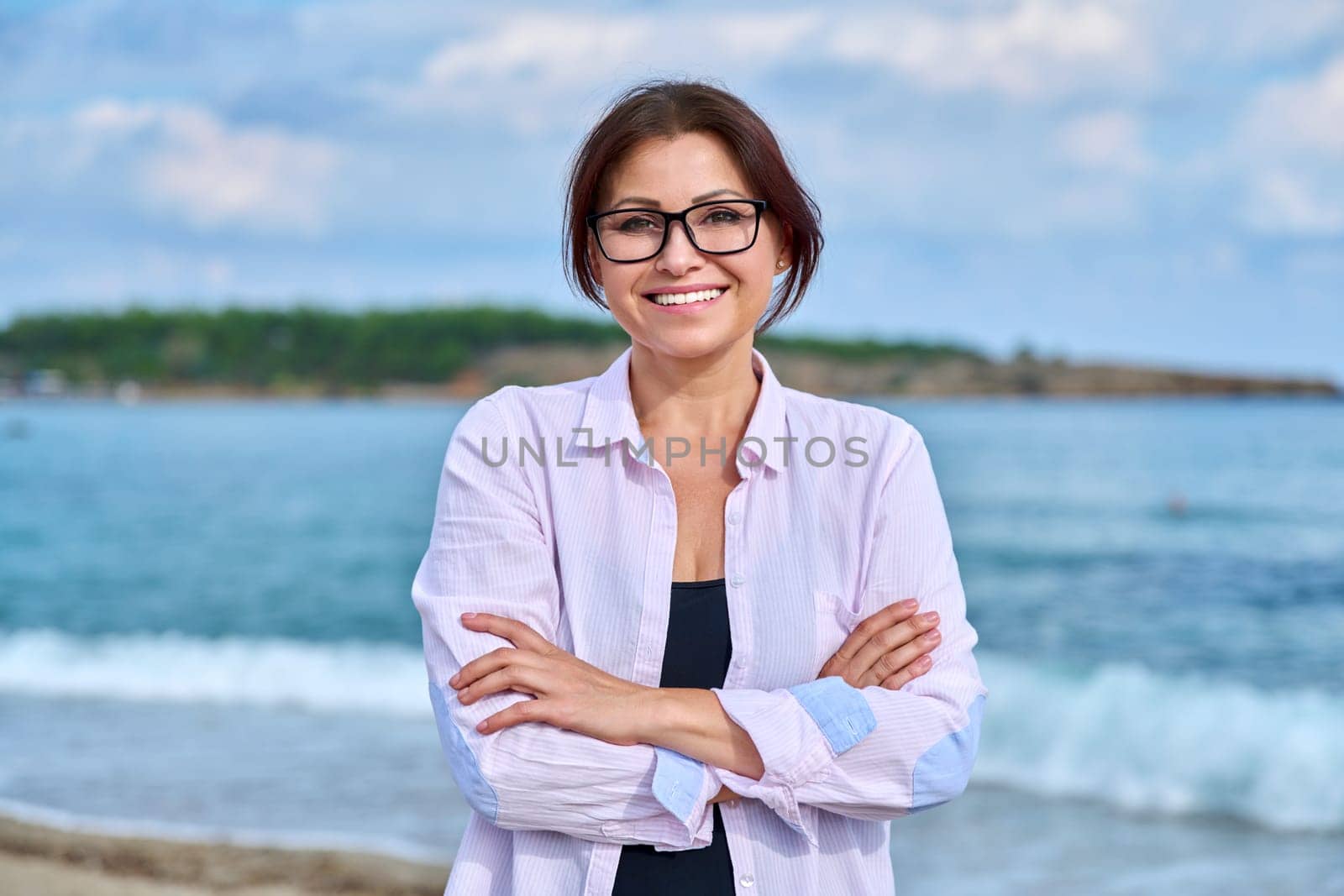 Outdoor portrait of mature smiling woman on sea vacation by VH-studio
