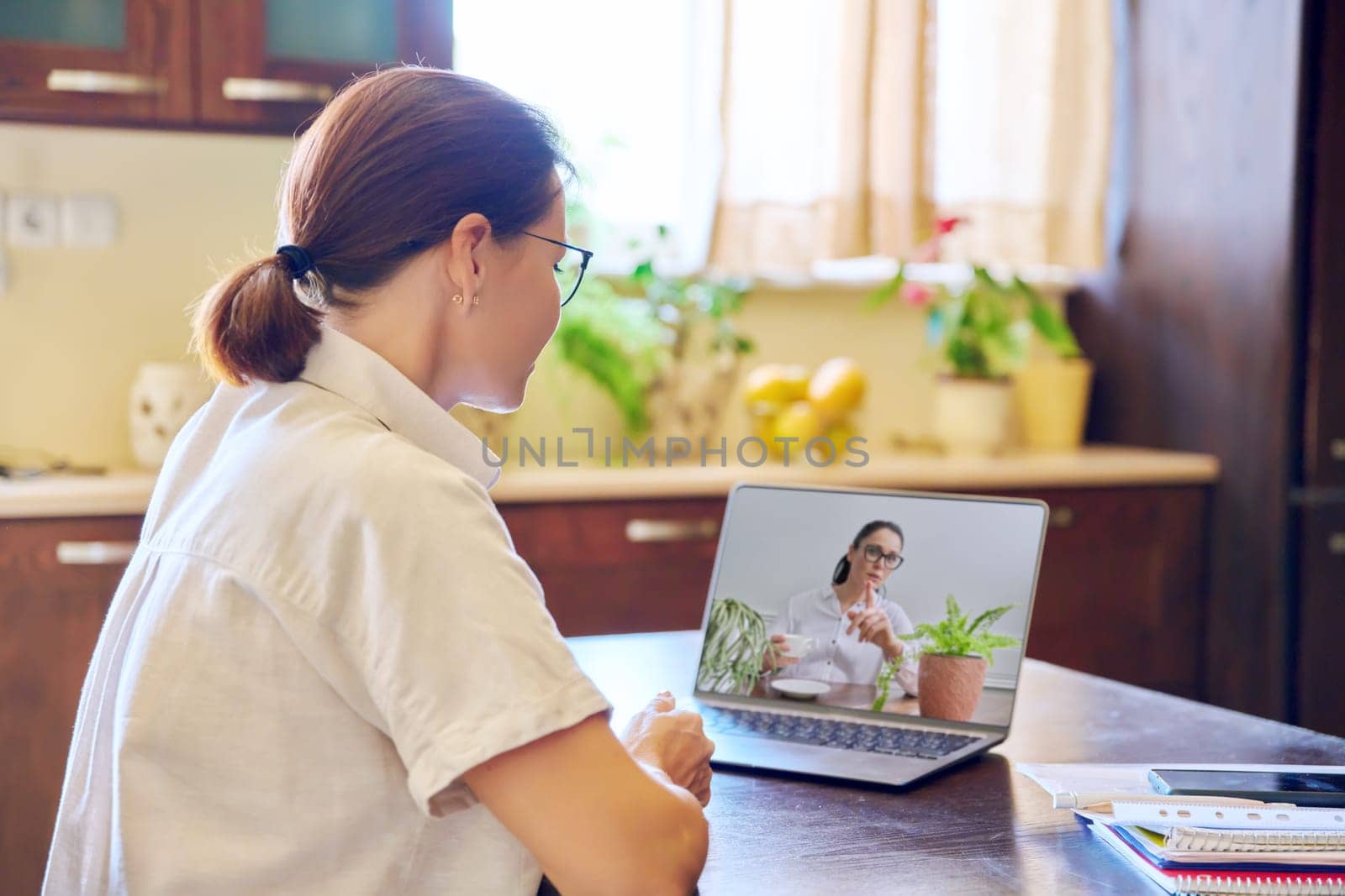 Women colleagues friends talking online by video call on laptop. by VH-studio