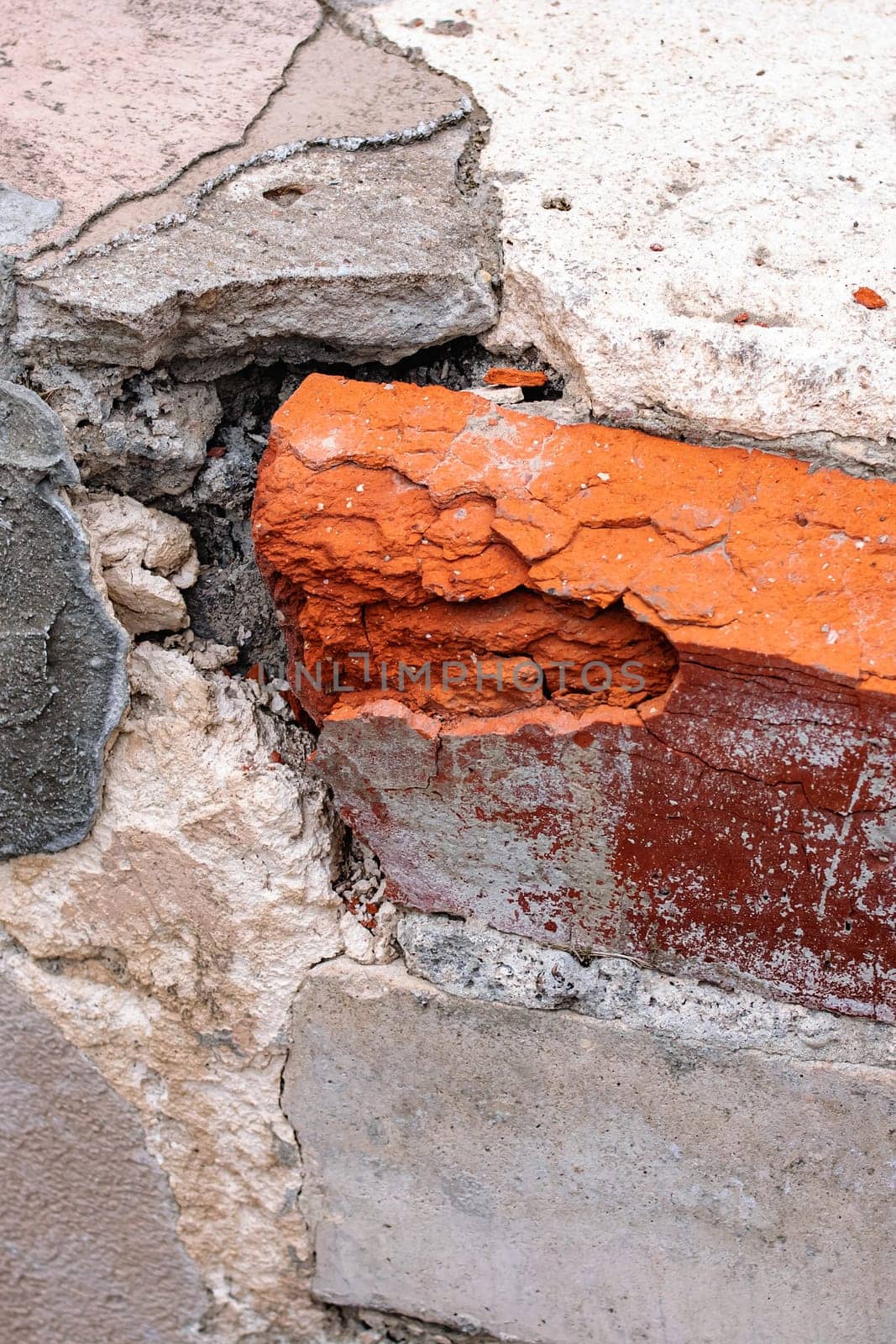 Old broken red brick wall with debris close up