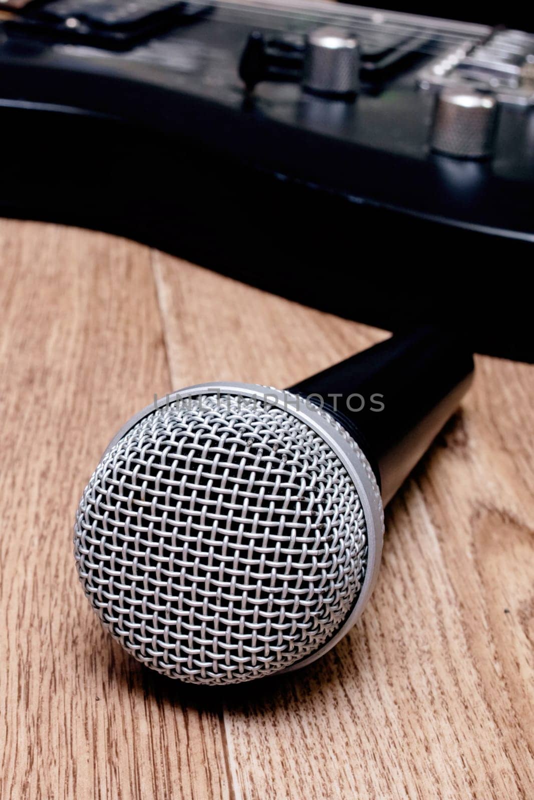 Microphone and guitar on a wooden background, copy space