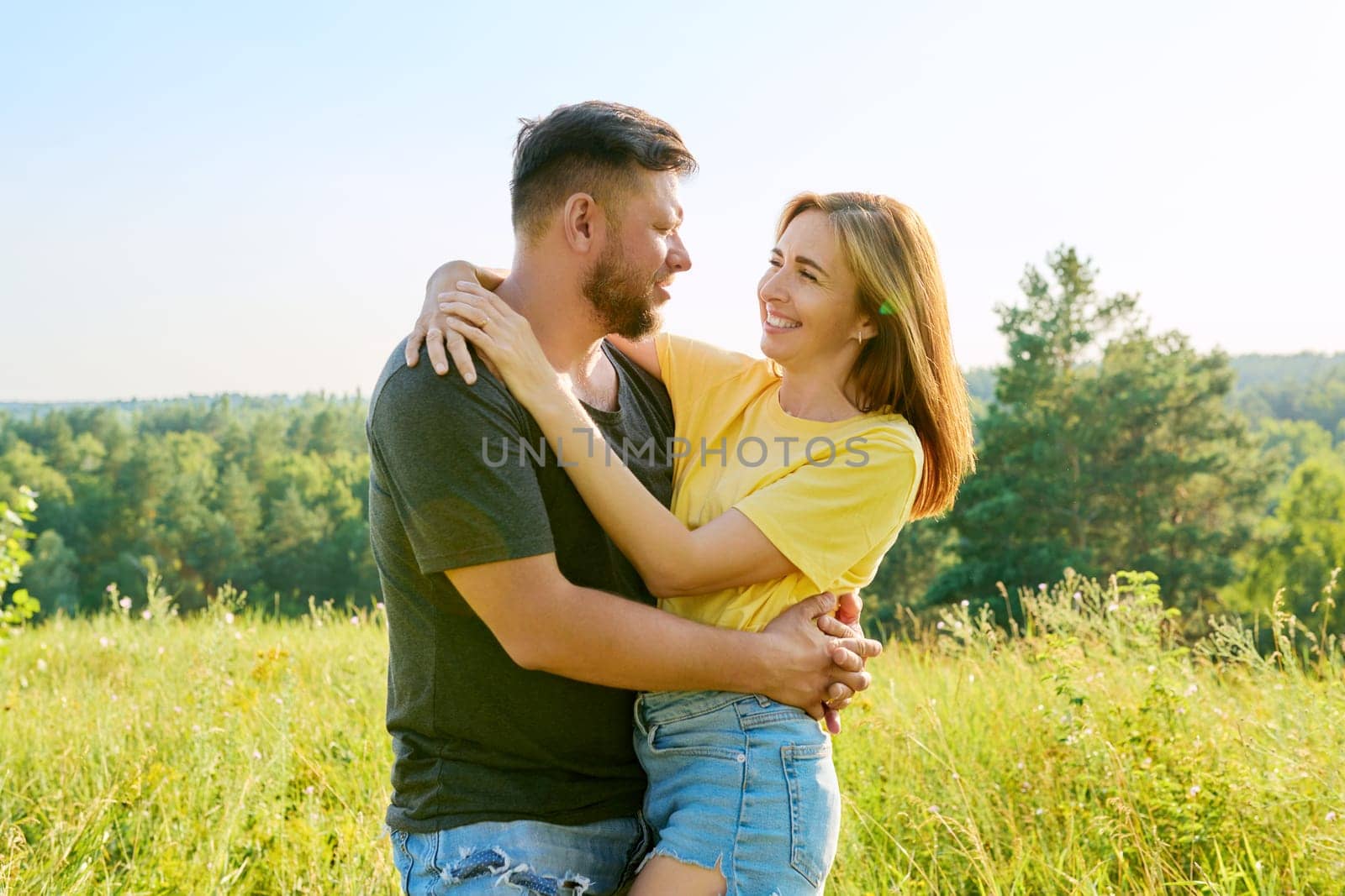 Outdoor portrait of happy middle age couple in love embracing by VH-studio