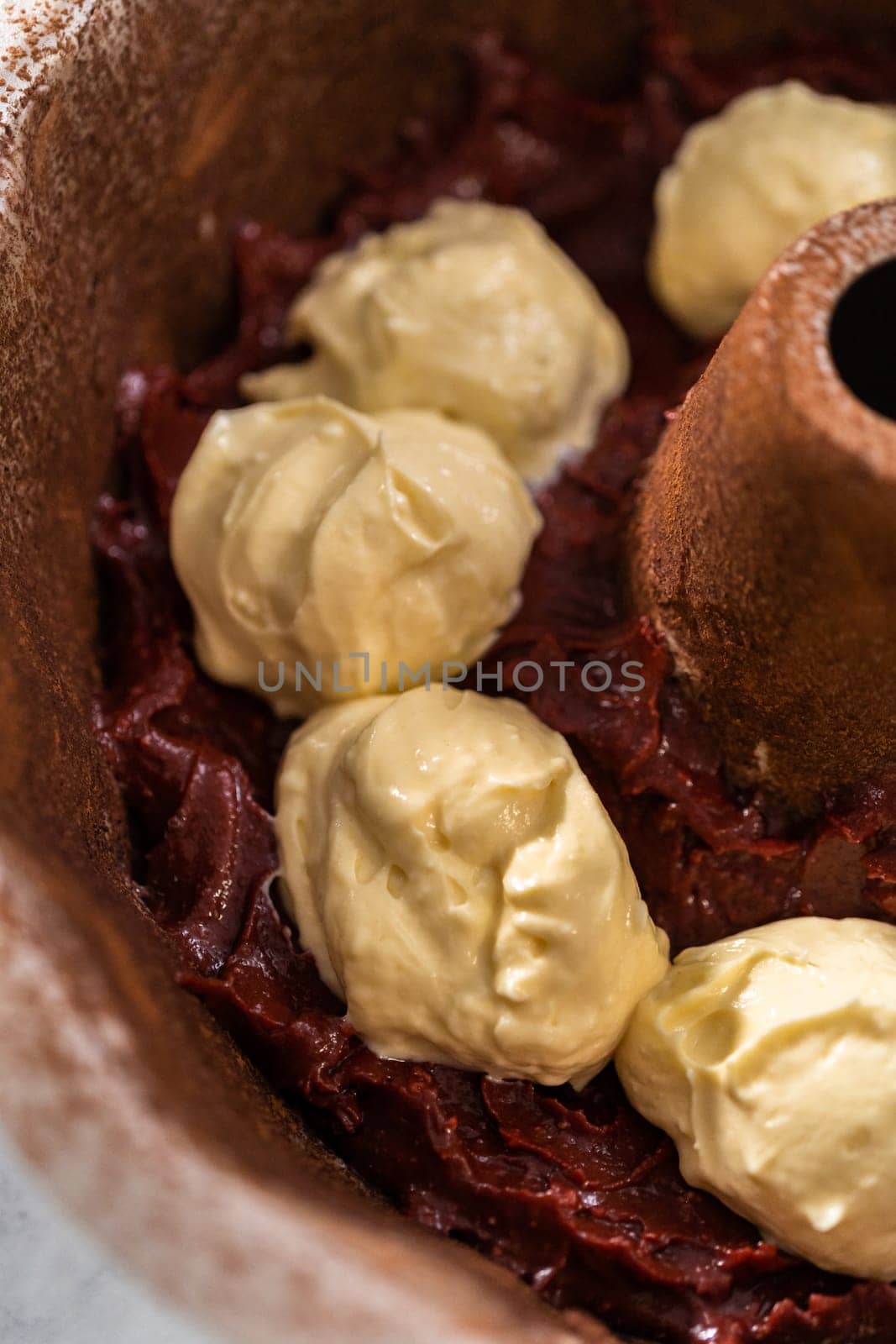 Filling metal bundt cake pan with cake butter to bake red velvet bundt cake with cream cheese glaze