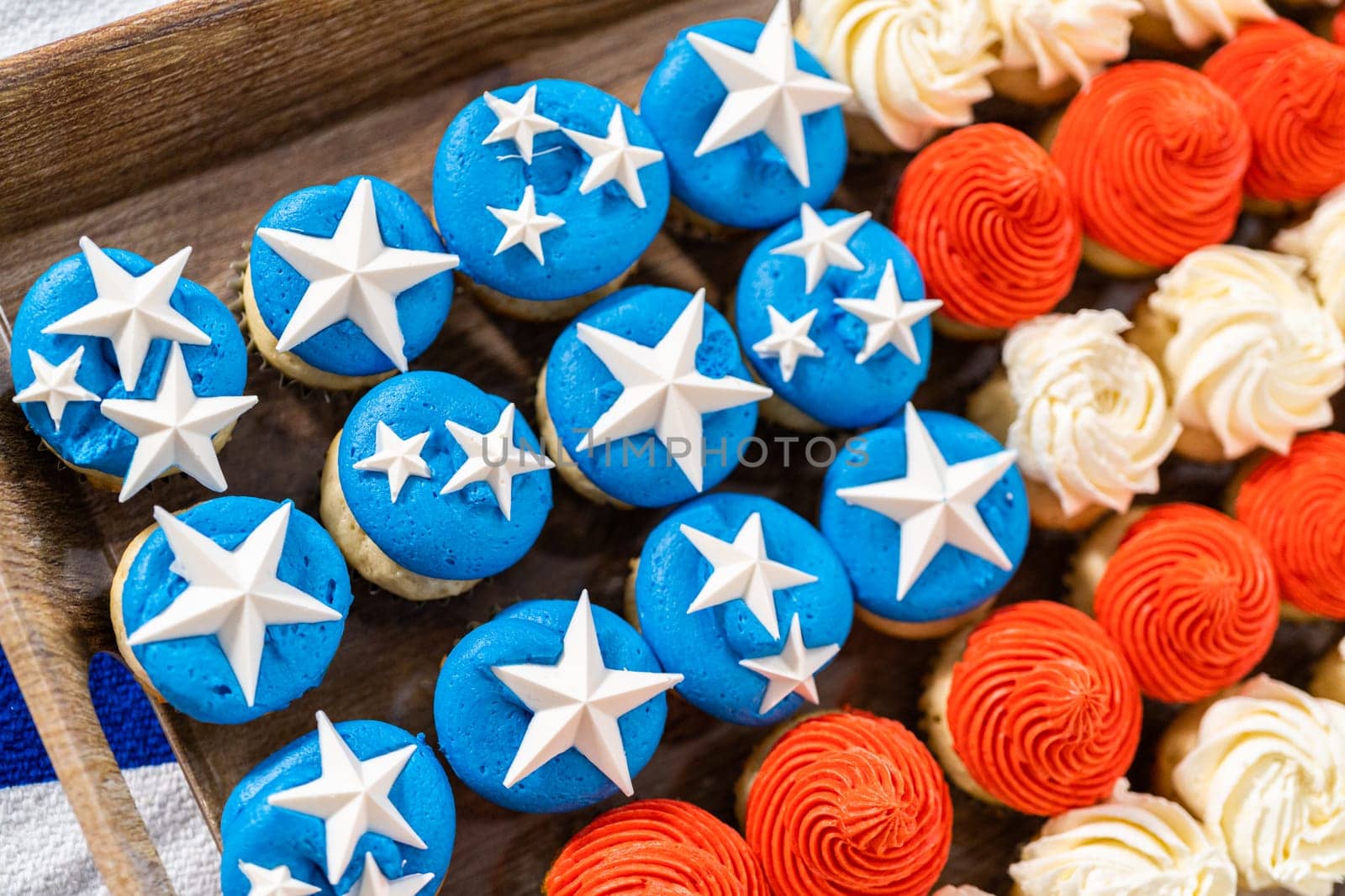 Arranging mini vanilla cupcakes in the shape of the American flag.