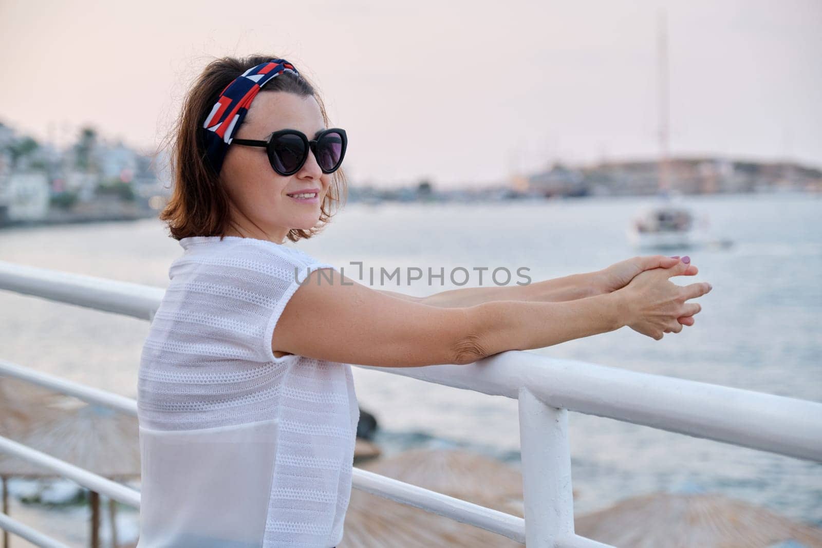 Mature beautiful woman in sunglasses enjoying the sea landscape. Vacation, seaside weekend, lifestyle, middle-aged people concept