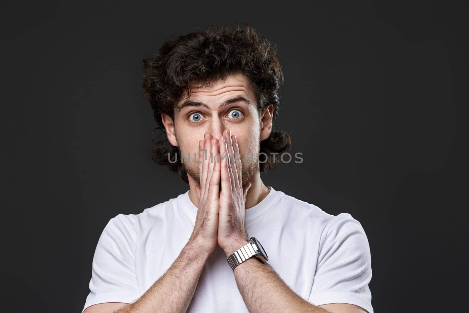 Portrait of frustrated young man on dark gray background. sadness