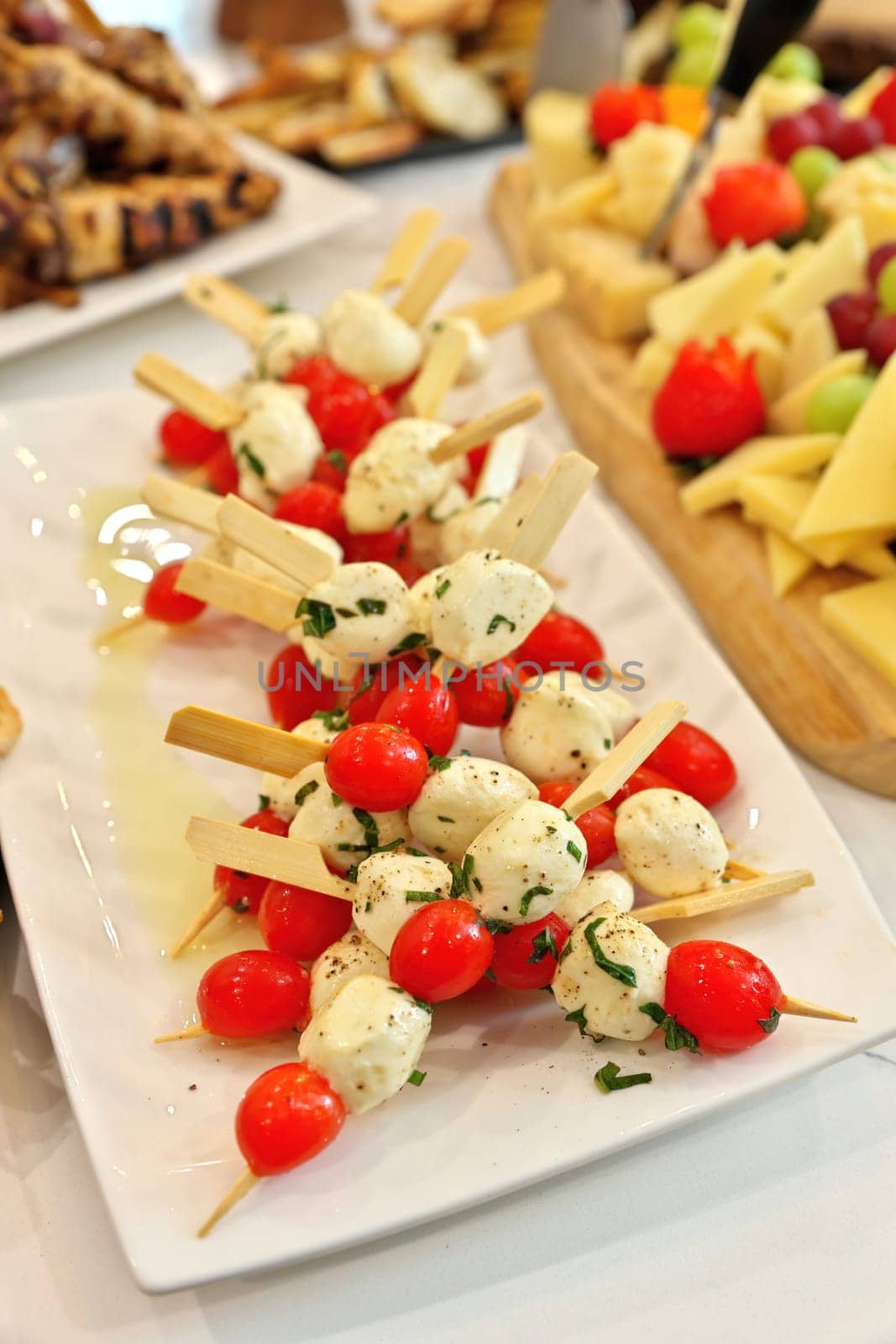 Caprese salad skewers made of cherry tomatoes, bocconcini, basil, and balsamic reduction by markvandam