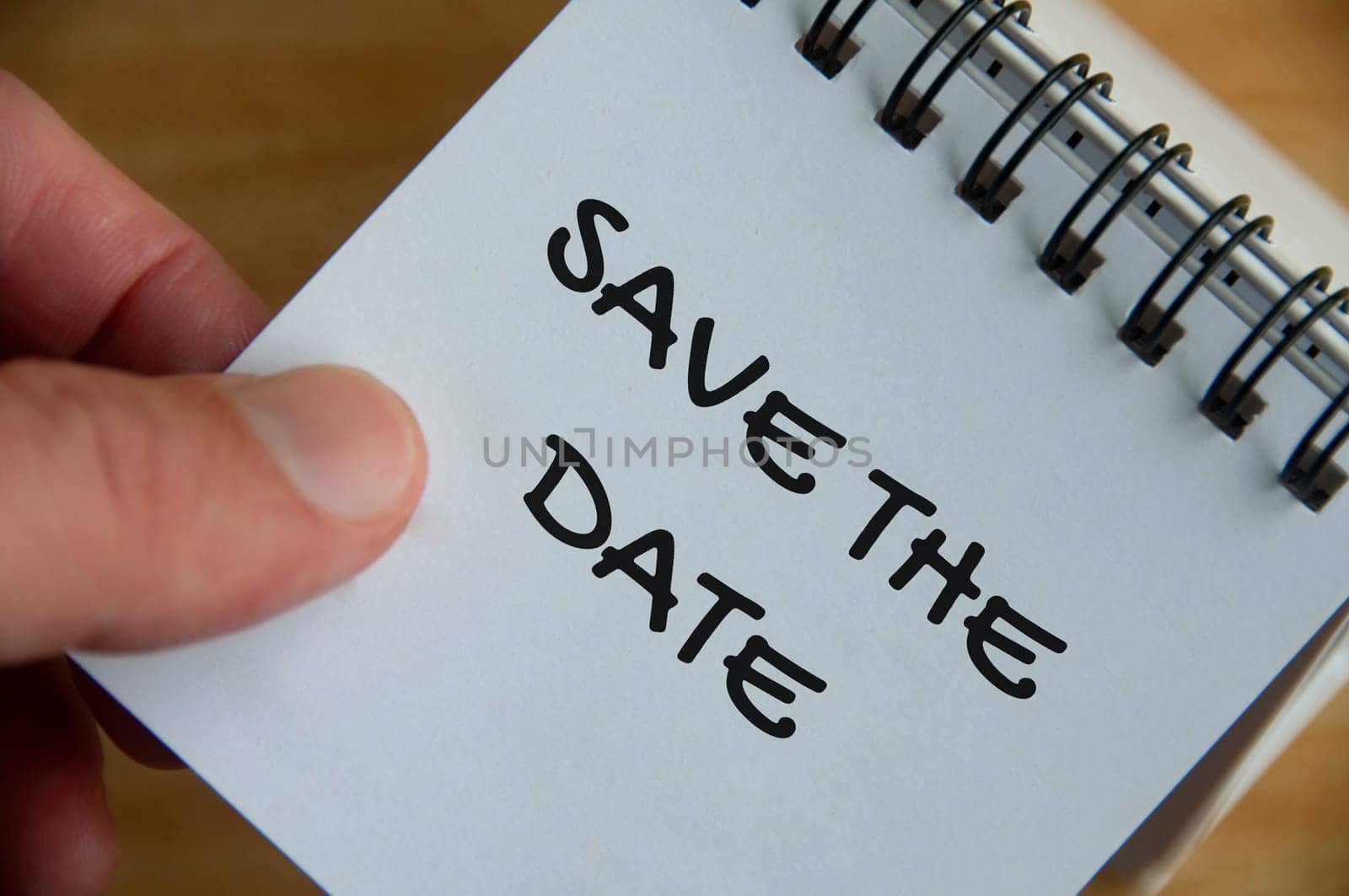 Top view of Save The Date text on white notepad. Business concept.