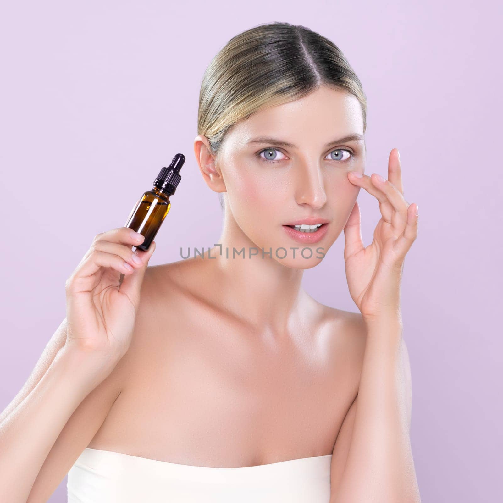 Alluring portrait of beautiful cosmetic skin woman apply extract cannabis oil bottle for skincare product on her face. Cannabis and CBD oil for facial treatment beauty concept. Pink isolated backdrop