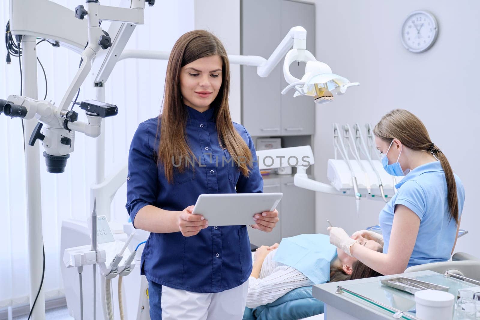 Portrait of young female doctor dentist with digital tablet in dental office by VH-studio