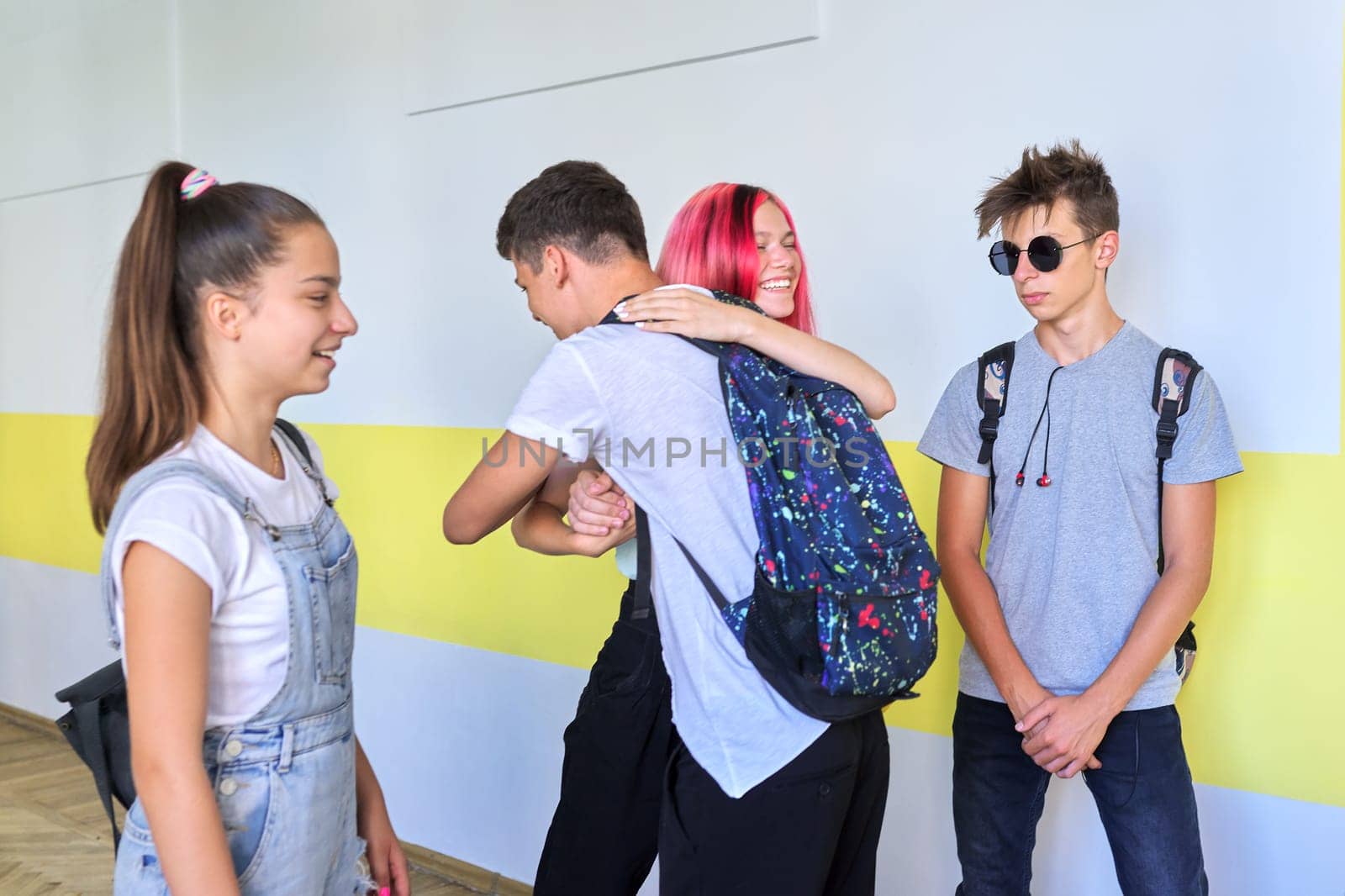 Meeting of teenage students at school, greeting and hugging. Friendship, school, college, teenagers concept