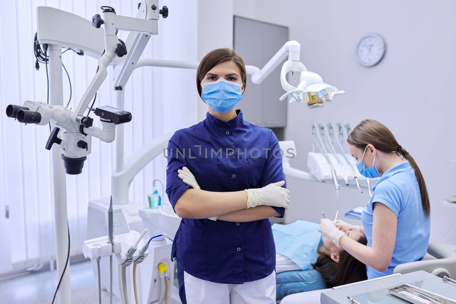 Portrait of young female doctor dentist in medical face mask in dental office by VH-studio