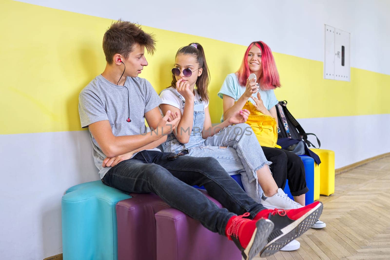 Group of teenage students at school sitting resting talking. Teens, friendship, youth, school, college concept