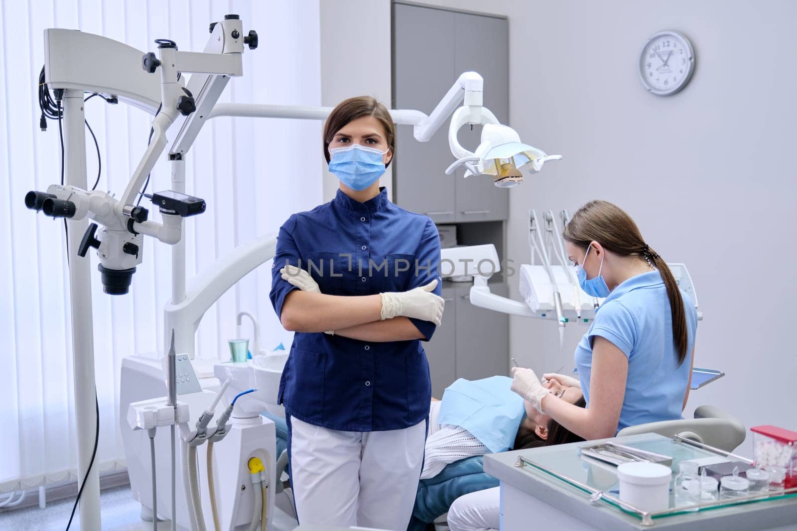 Portrait of young female doctor dentist in medical face mask in dental office by VH-studio