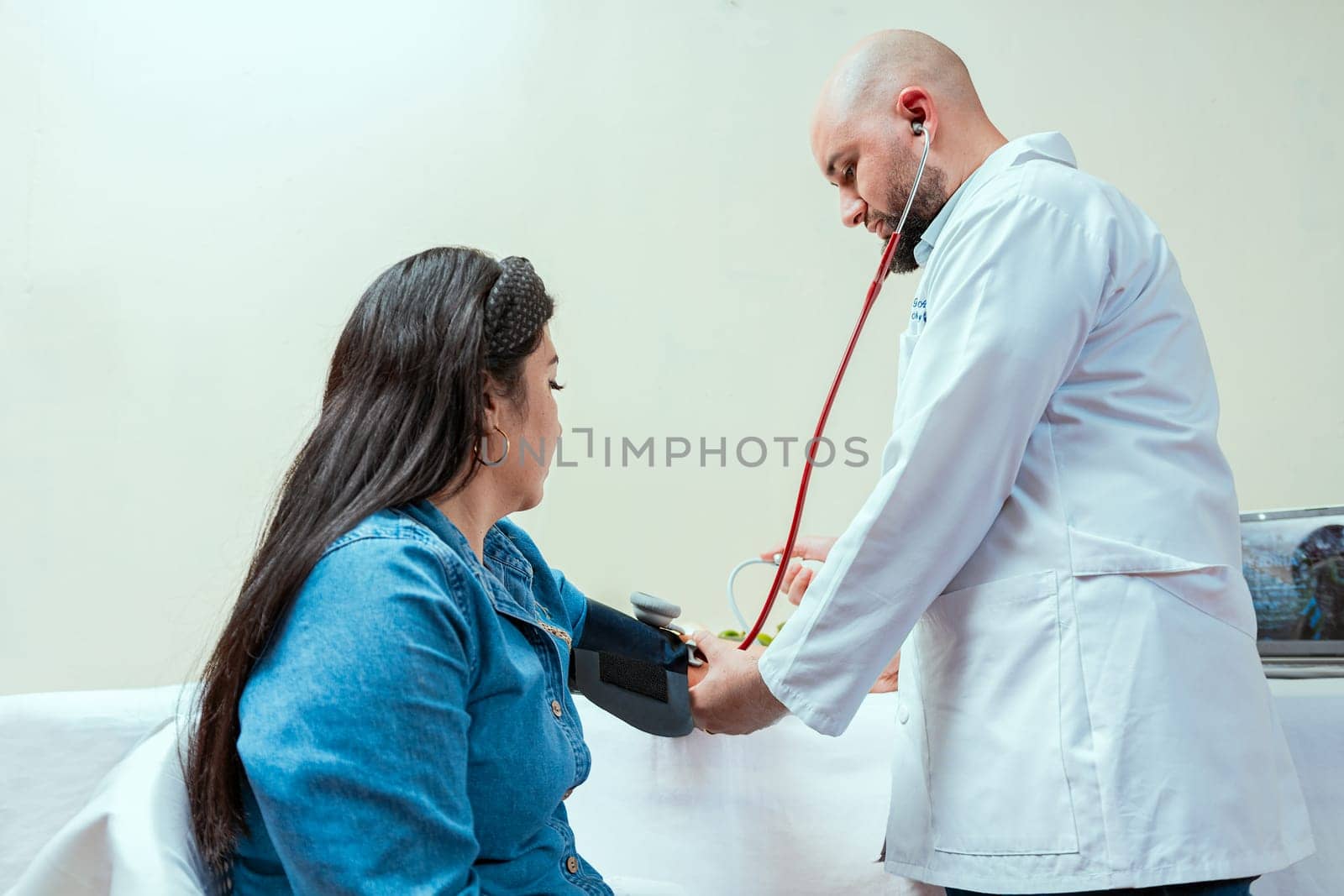 Measuring blood pressure to patient in the office, Nutritionist man measuring blood pressure to female patient in office, Nutritionist measuring blood pressure to patient by isaiphoto